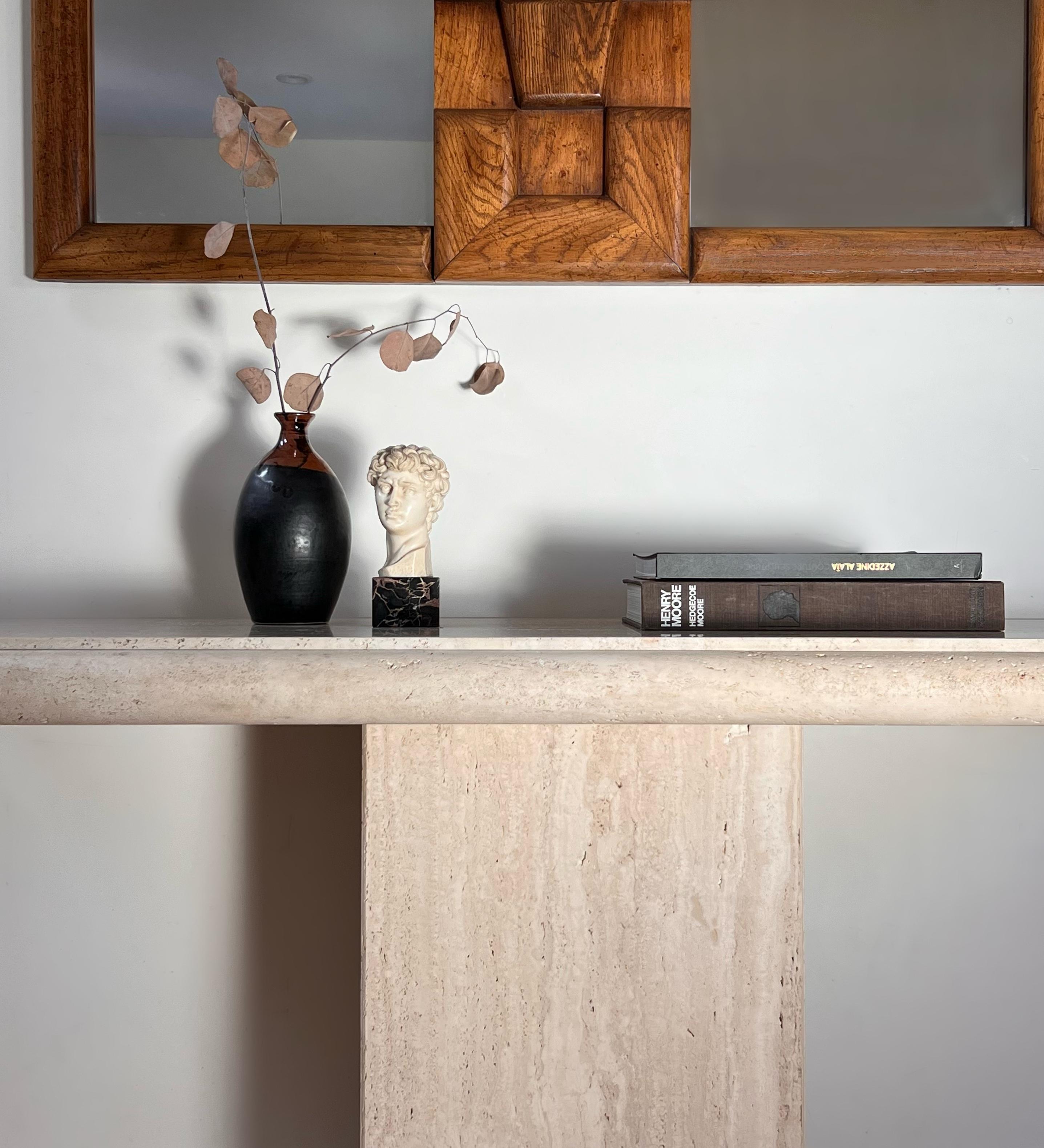 A travertine console by Stone International, early 1970s. Thick bullnose edge, pedestal base. Wear consistent with age and use and but no outward or glaring flaws; overall fabulous condition. Very heavy but the table does dismantle into two pieces