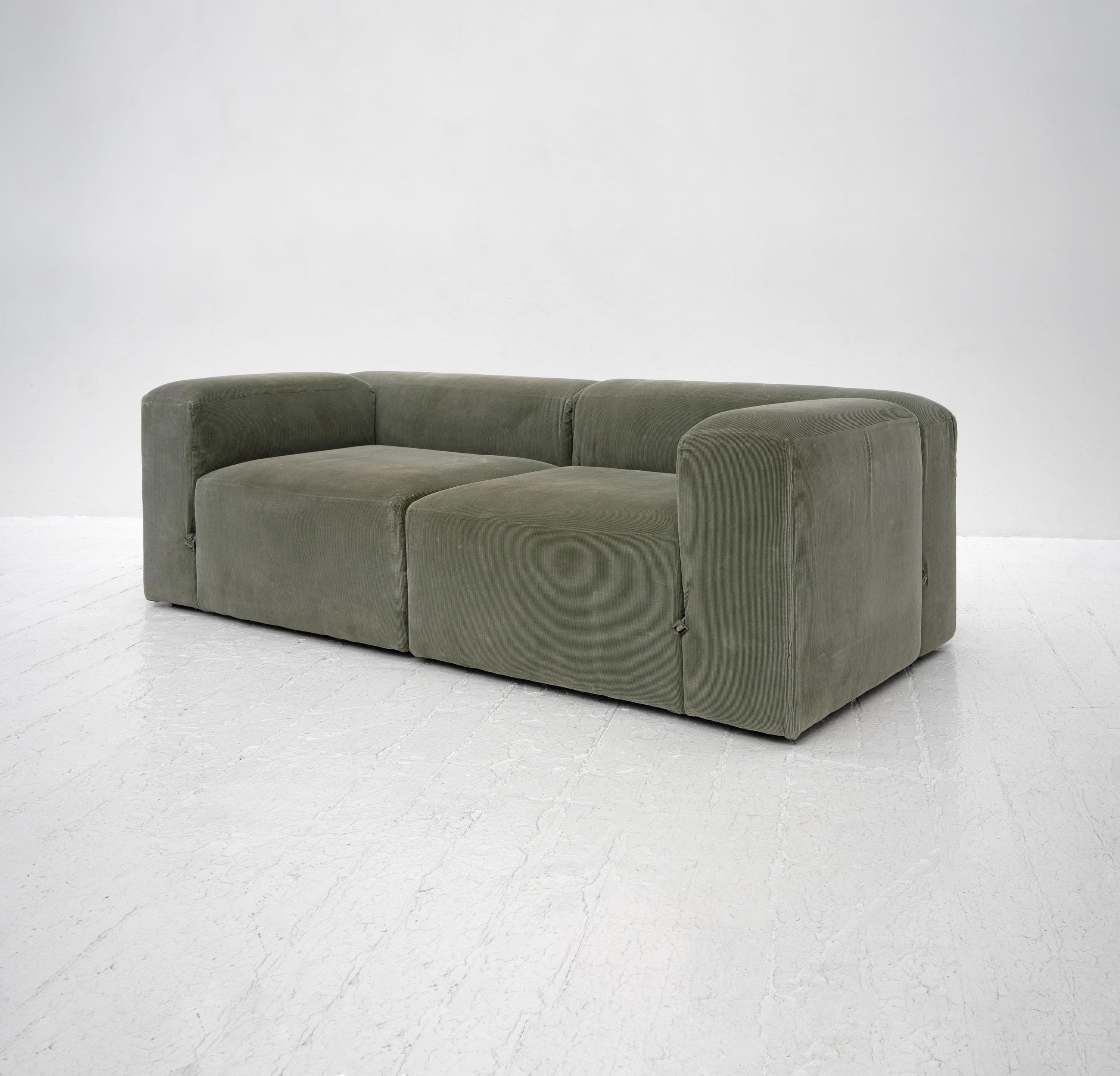 A late 20th Century modular sofa upholstered in soft green corduroy and featuring strap and buckle detailing after Mario Bellini's Le Mura.

Dimensions (cm, approx):
Height: 66
Width: 226
Depth: 97

In good condition for its year with no rips to the