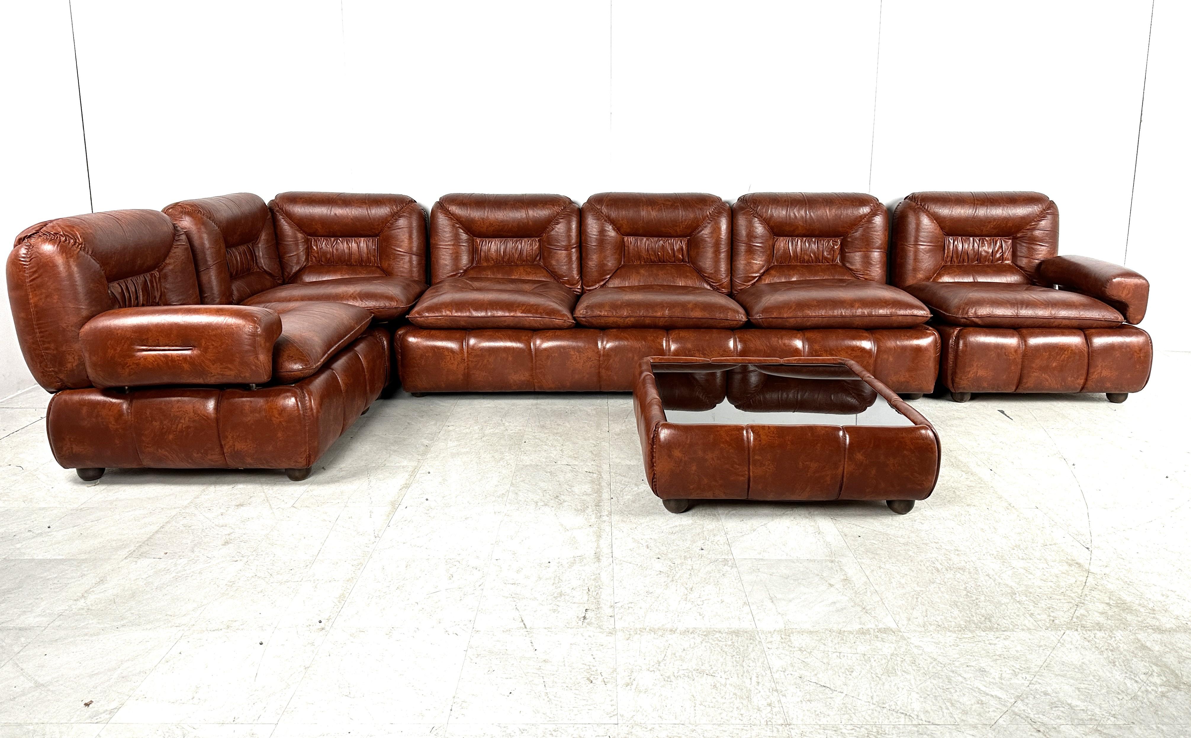 Seventies design sofa set made from simili leather with beautiful flamed pattern.

Comes with a coffee table.

The armrests are interchangeable so you can create your own setup (L shaped, one long sofa,..)

Very comfortable sofa set with a beautiful