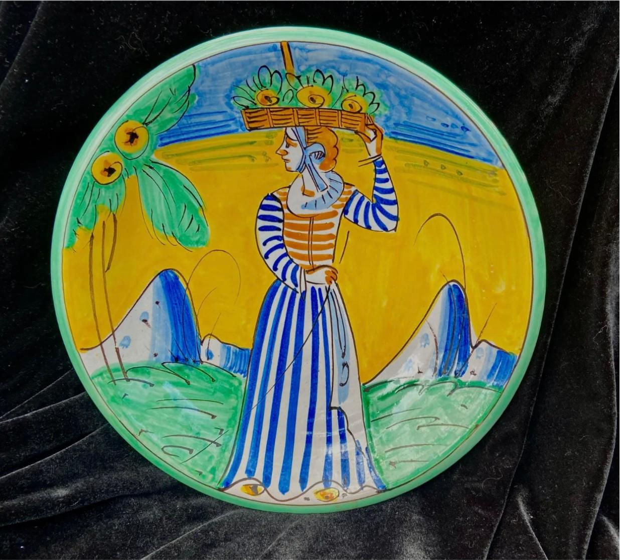 This beautiful pottery charger is is decorated with a woman carrying a basket of flowers on her head. Vividly painted in yellows, greens, and blues. Condition is very good, does have minor chips commiserate with age and use. Back is signed Vincent