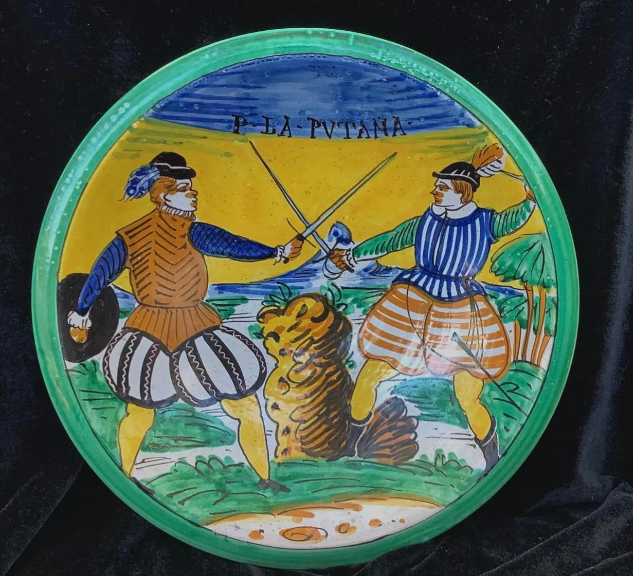 This beautiful pottery charger is from Montelupo, Italy and is hand painted with two soldiers sword fighting. Vividly painted in yellow, green, and blue. Condition is very good, does have minor chips commiserate with age and use. Diameter of charger