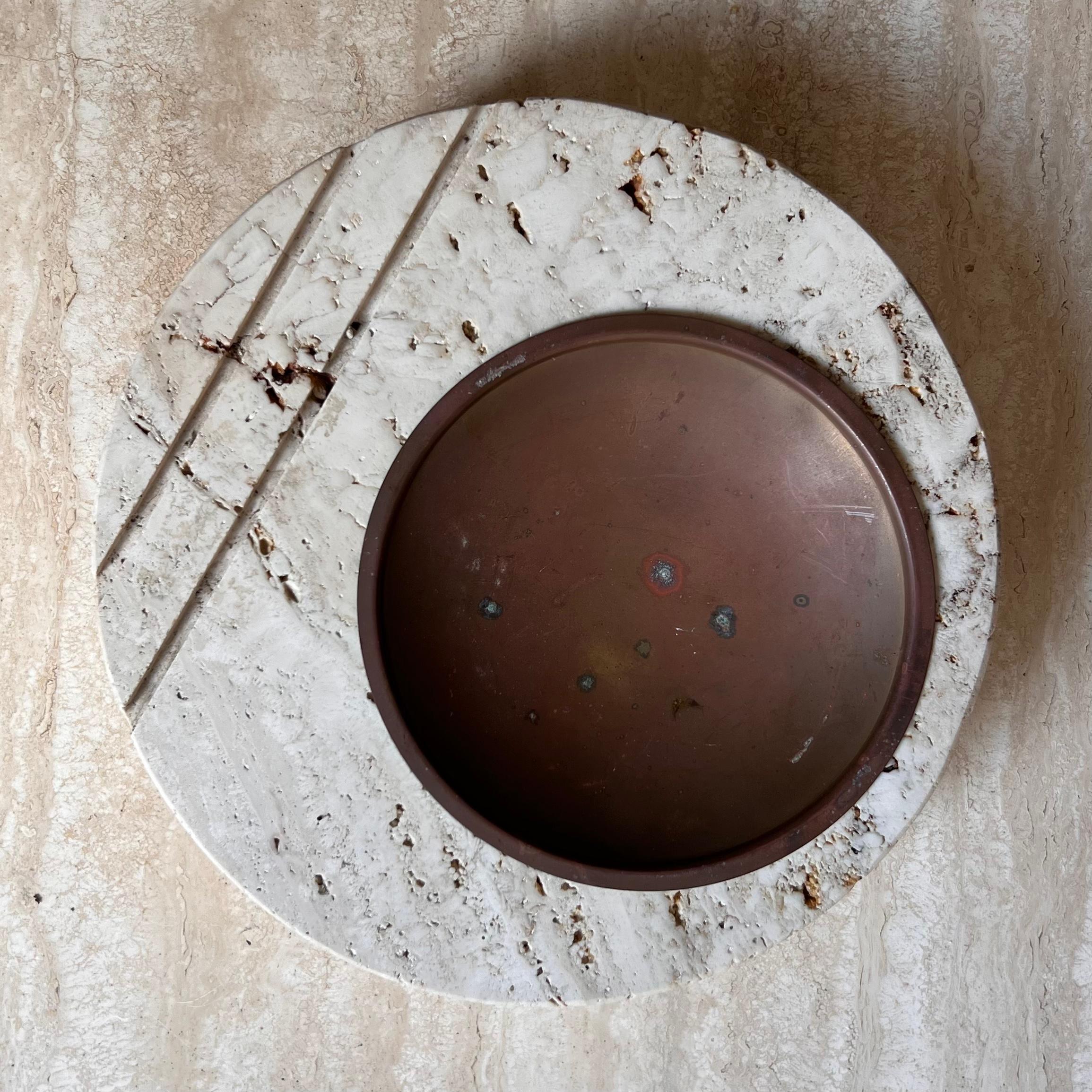 A large and heavy stone ashtray by postmodern Italian designed Fratelli Mannelli, circa 1970. Hand-carved out of raw travertine and featuring a sienna-toned metal inlay, as well as the iconic Mannelli lines which are seminal to the postmodern