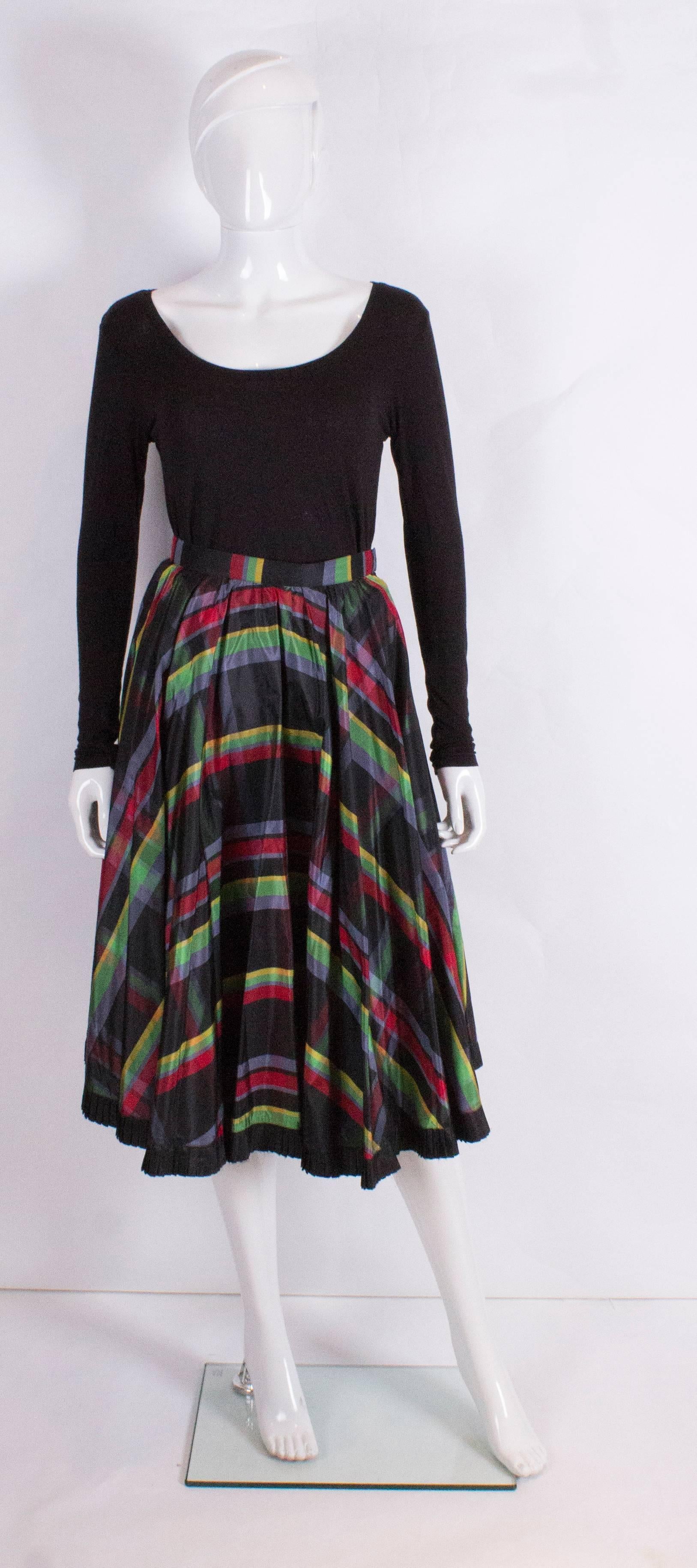 A fun skirt for Fall. This vintage  silk skirt has a black background with coloured stripes. 
It also has a seperate black silk underskirt with frilled hem.