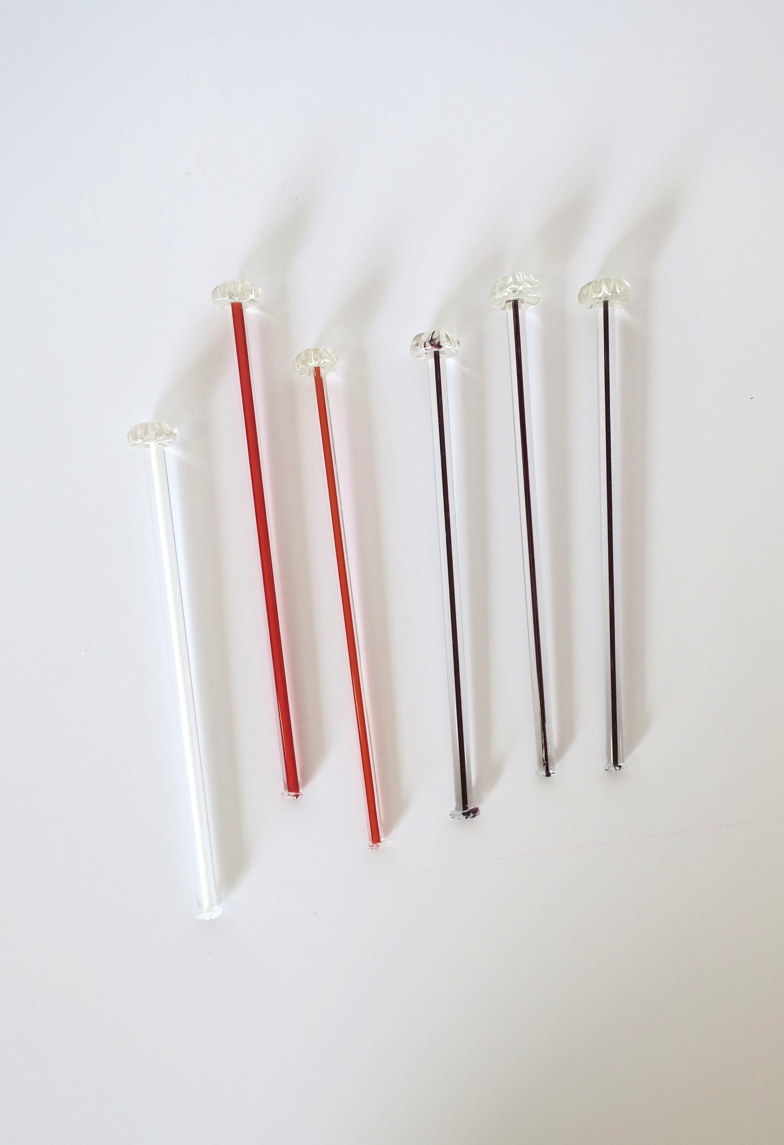 A very beautiful set of six (6) vintage Italian Murano barware art glass cocktail stirrers, Mid-Century Modern period, mid-20th century, Italy. Set is hand-crafted in transparent/clear, red, plum and white art glass hues, finished with floweret top