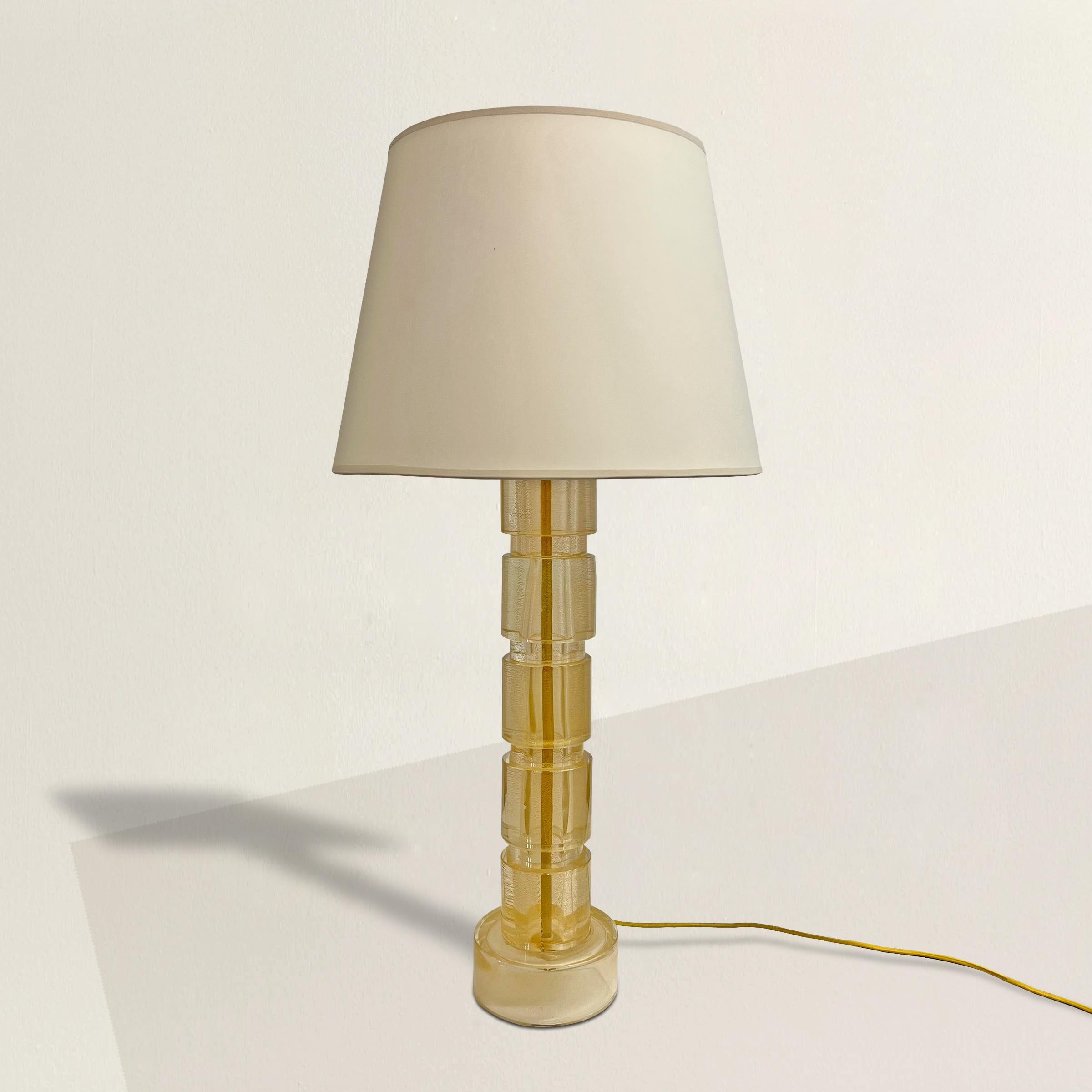 An arresting vintage Italian Murano Avventurina glass table lamp with a chic silhouette, paper shade, and sparkling gold fleck inclusions that catch even the softest light in the room. Avventurina glass is a 17th century Italian glass making