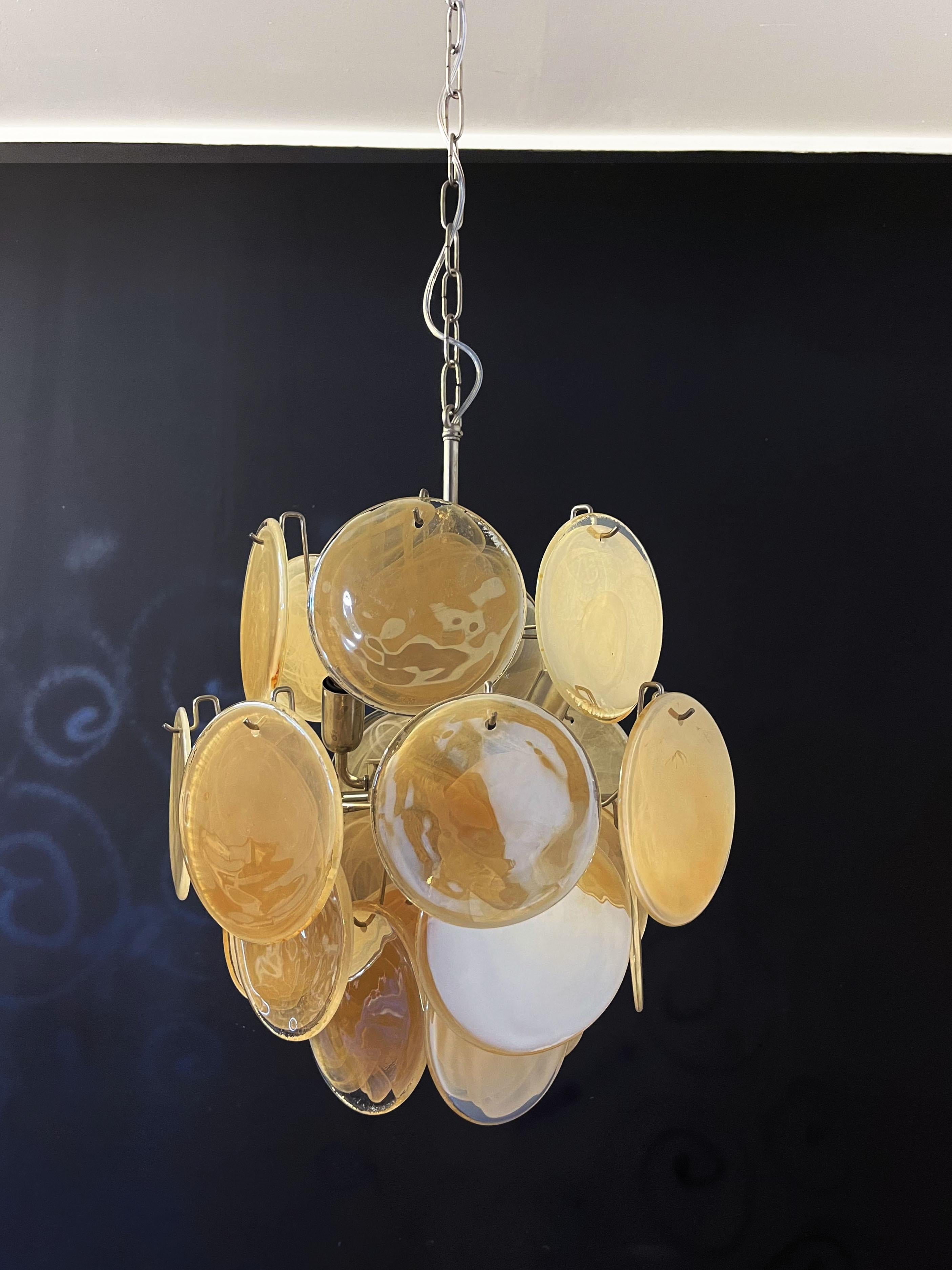 Vintage Italian Murano chandelier in Vistosi style. The chandelier has 24 fantastic iridescent alabaster honey discs in a nickel metal frame.
Period: late 20th century
Dimensions: 41,30 inches (105 cm) height with chain; 20,50 inches (52 cm)