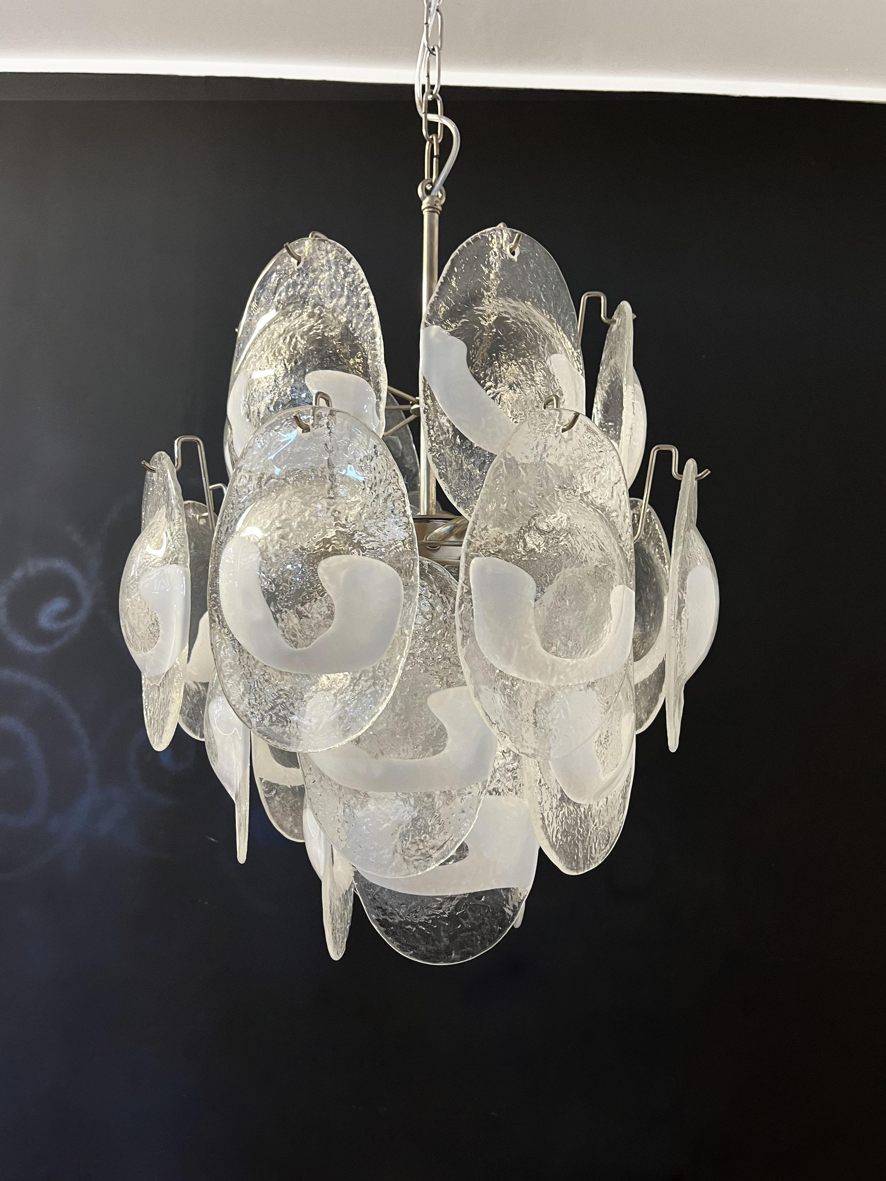 Vintage Italian Murano chandelier in Vistosi style. The chandelier has 24 glasses in a nickel metal frame. The originality of this chandelier is given by the glass, wonderful works of art trasparent and white lattimo, called shells. Murano blown