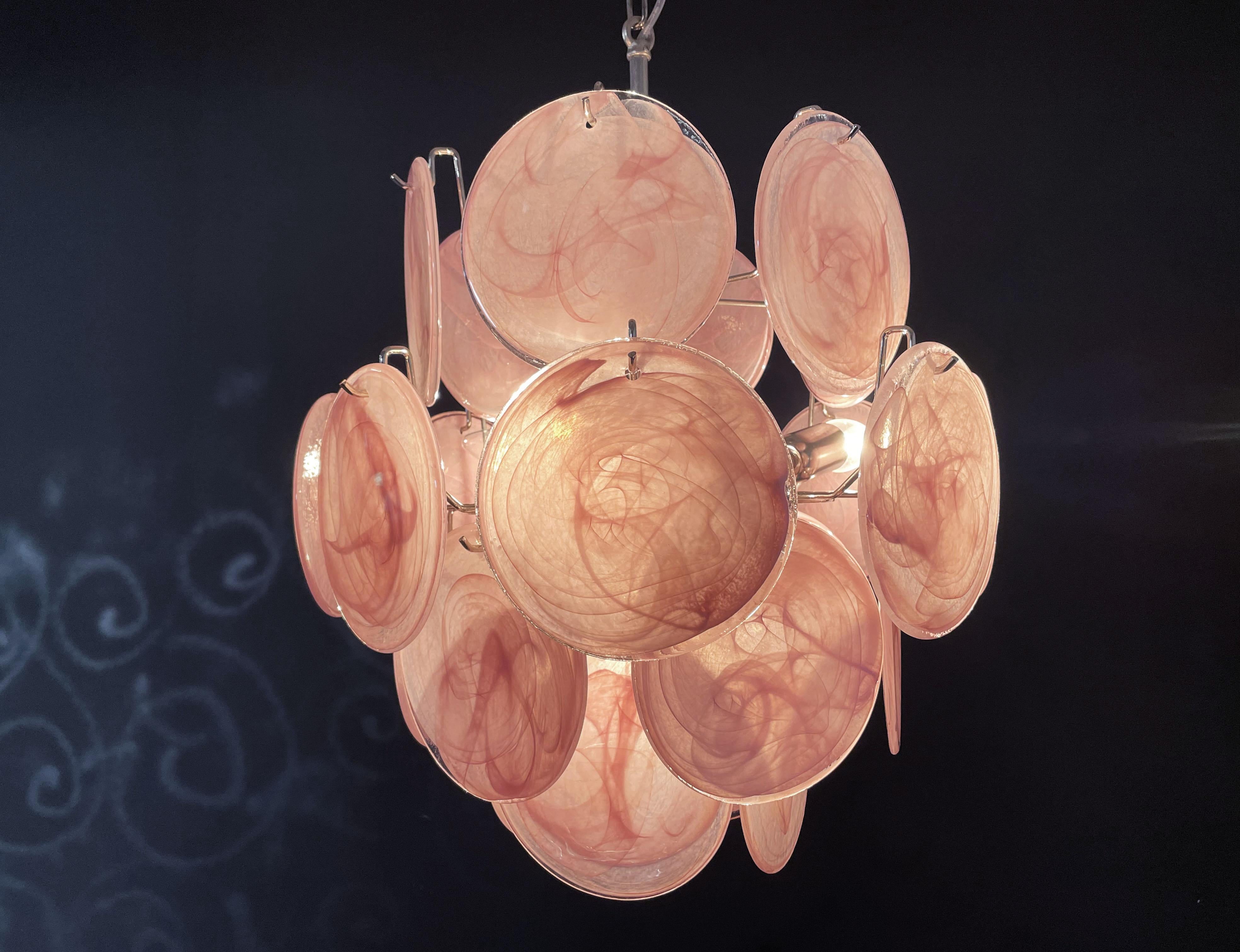 Vintage Italian Murano chandelier in Vistosi style. The chandelier has 24 fantastic iridescent alabaster pink discs in a nickel metal frame.
Period: late XX century
Dimensions: 41,30 inches (105 cm) height with chain; 20,50 inches (52 cm) height