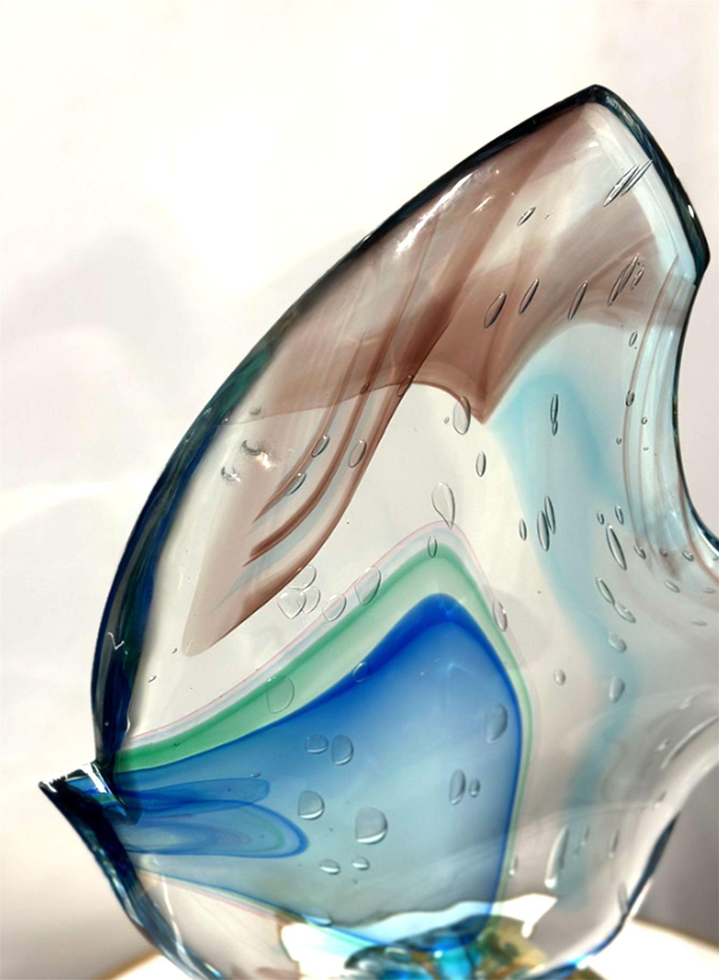 Abstrakte Fischskulptur von Sergio Costantini für Vetro Artistico Murano mit blauen, gelben und braunen Akzenten auf klarem Muranoglas. Hergestellt in Italien, 20. Jahrhundert. Mit der Signatur des Künstlers und dem Originalaufkleber 