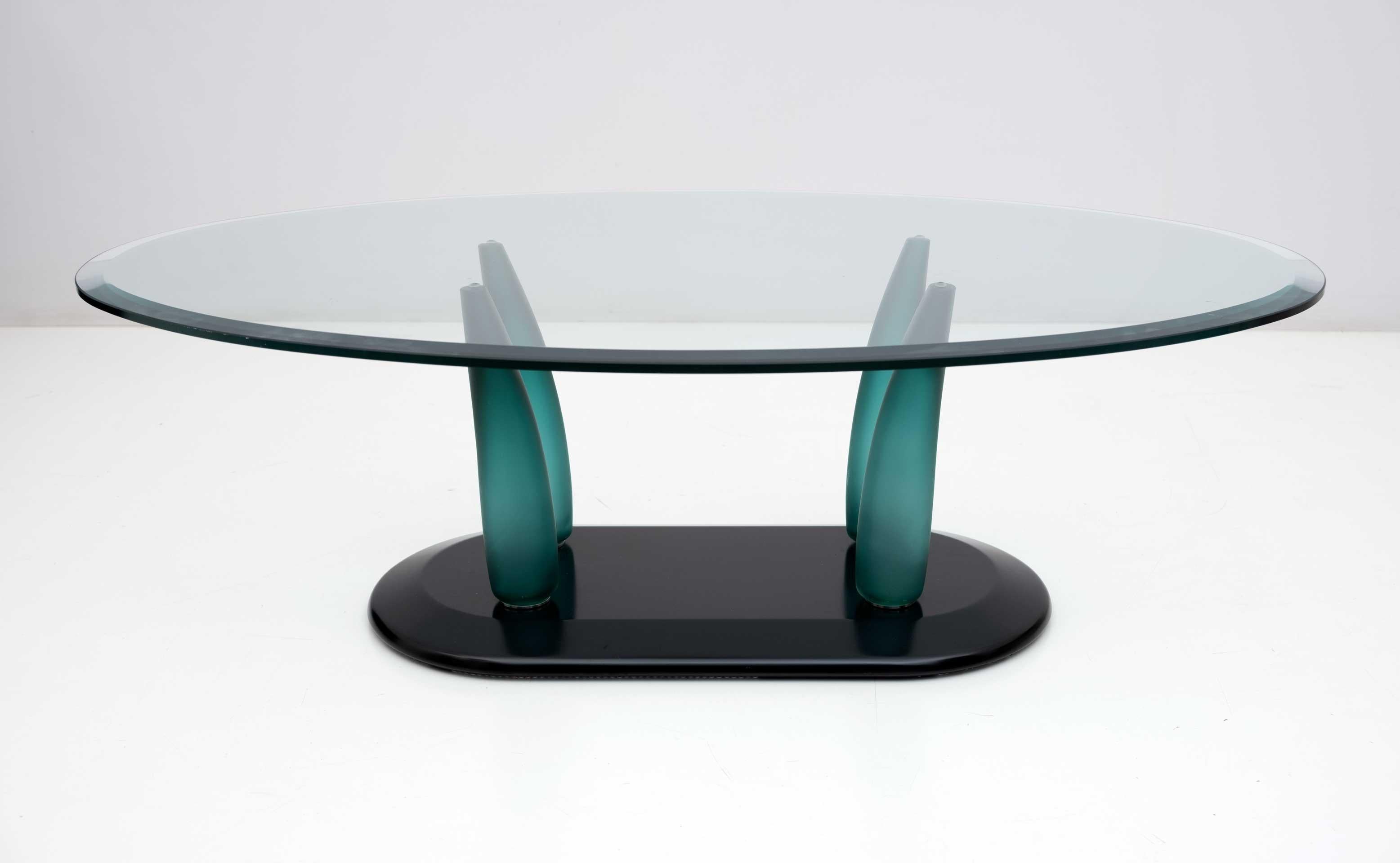Coffee table with base in black lacquered wood, legs in teal blown glass and top in oval shaped and ground glass, Seguso Murano manufacture, 1980s