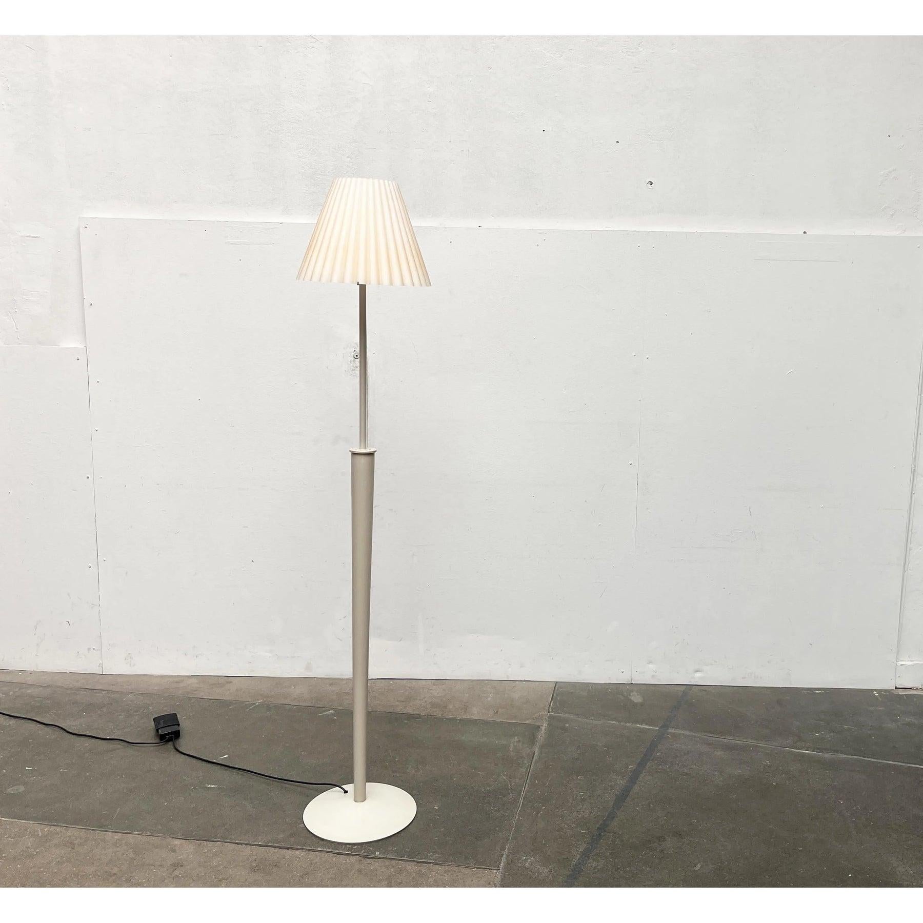 Italian floor lamp with a special base and shade.

The special detail of this lamp is the elaborate glass shade. The glass is designed in waves, imitating the shape of a classic fabric shade. It lies on a structure with three walkways. The offset