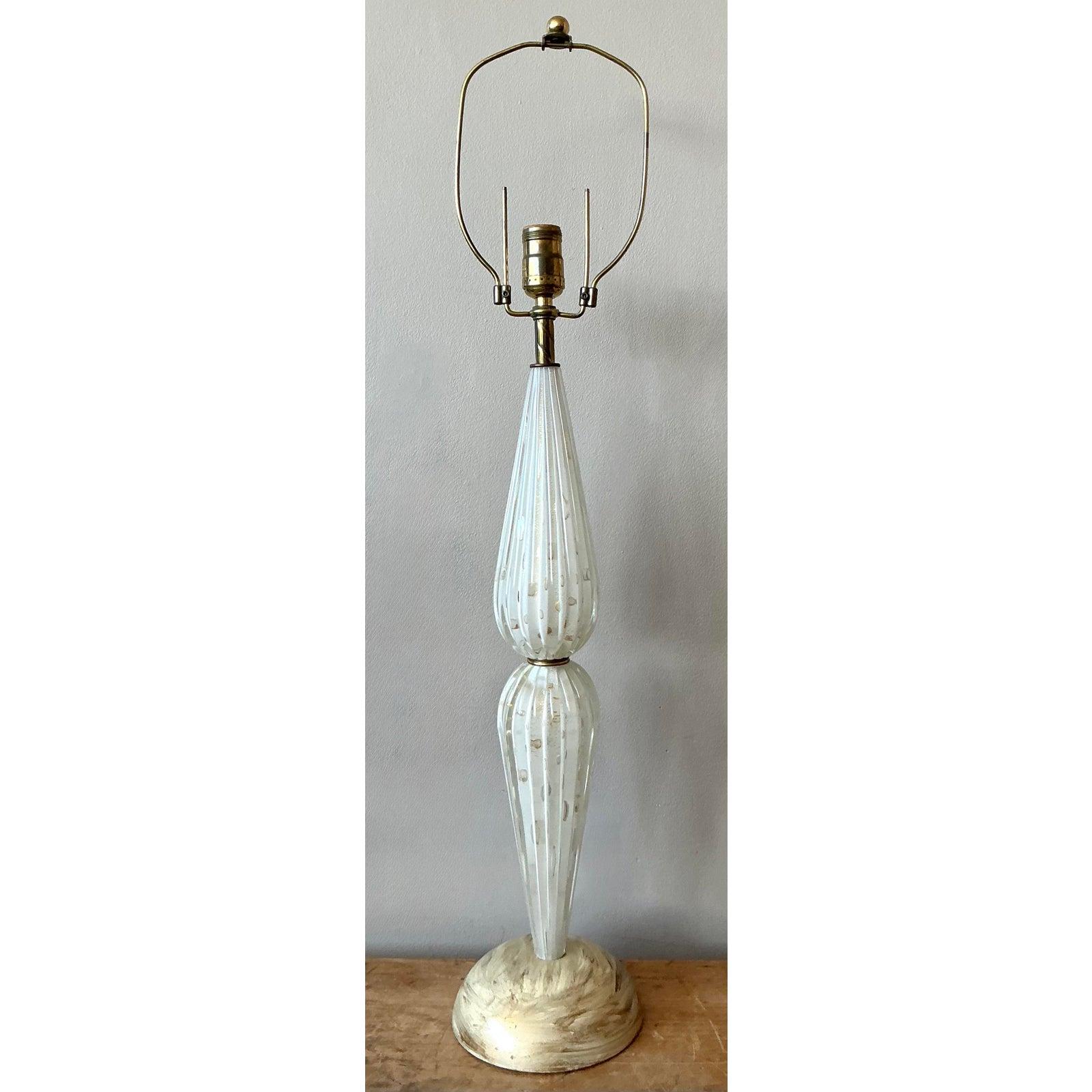 Illuminez votre espace avec l'art exquis de cette lampe de table en verre Murano italien vintage, un exemple étonnant du design moderne du milieu du siècle. Cette lampe présente un corps magnifiquement sculpté, composé de segments de verre blanc de