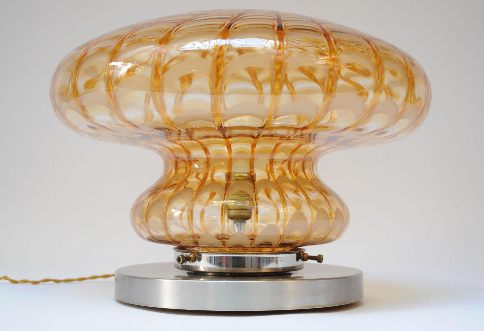 Tischlampe aus Murano-Glas in Form eines Pilzes, getragen von einem runden Aluminiumsockel (ca. 1970er Jahre, Italien).
Attraktives Muster in Bernstein- und Honigtönen.
Ausgezeichneter Vintage-Zustand mit leichten Abnutzungserscheinungen an der