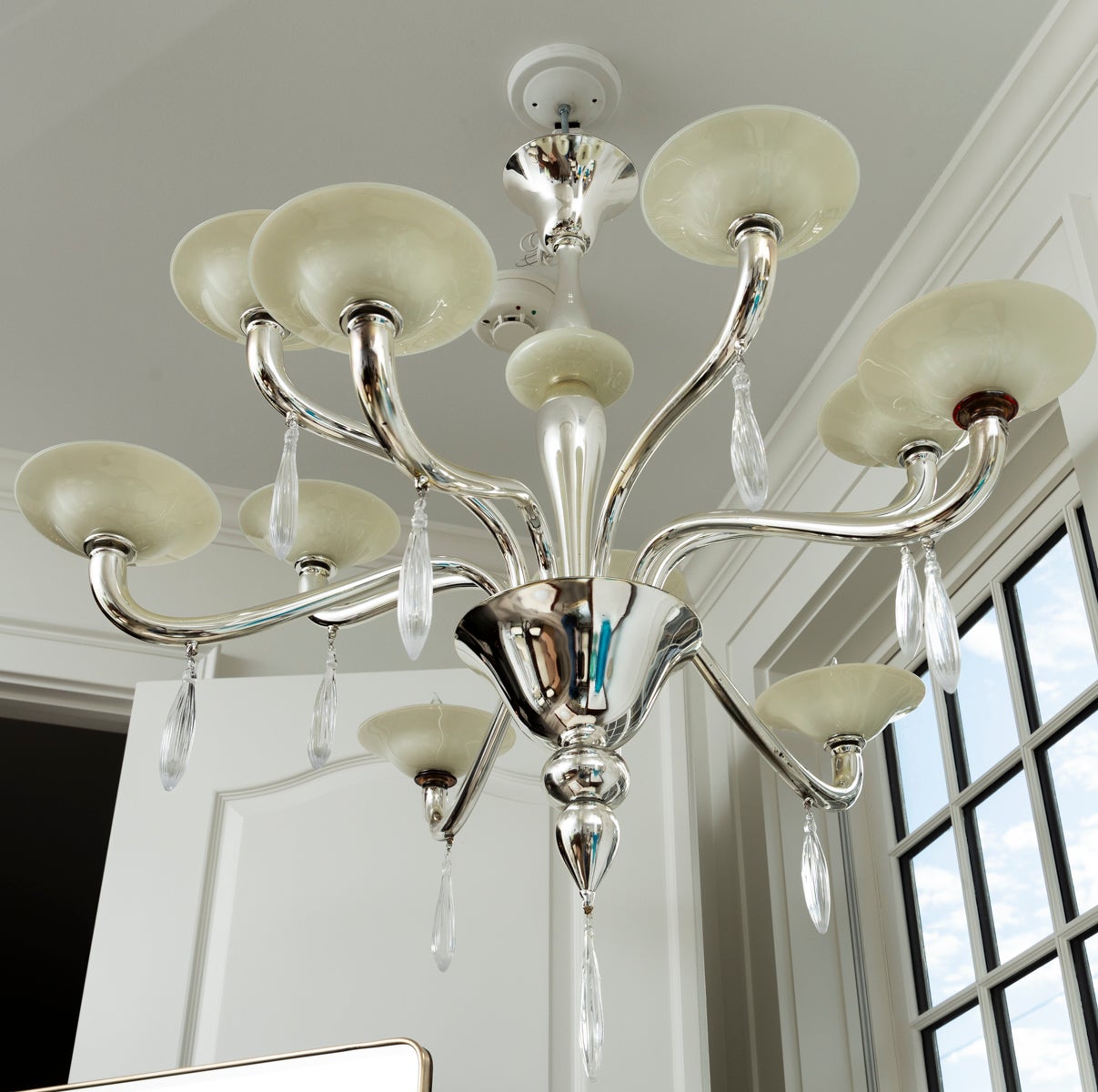  Un lampadario di Murano a due livelli, moderno e unico, composto da dieci bracci rovesciati in argento soffiato e da un'asta centrale che termina con raffinate gocce in cristallo soffiato e bombate.  Le bobeches (coppe) e la palla centrale  sono
