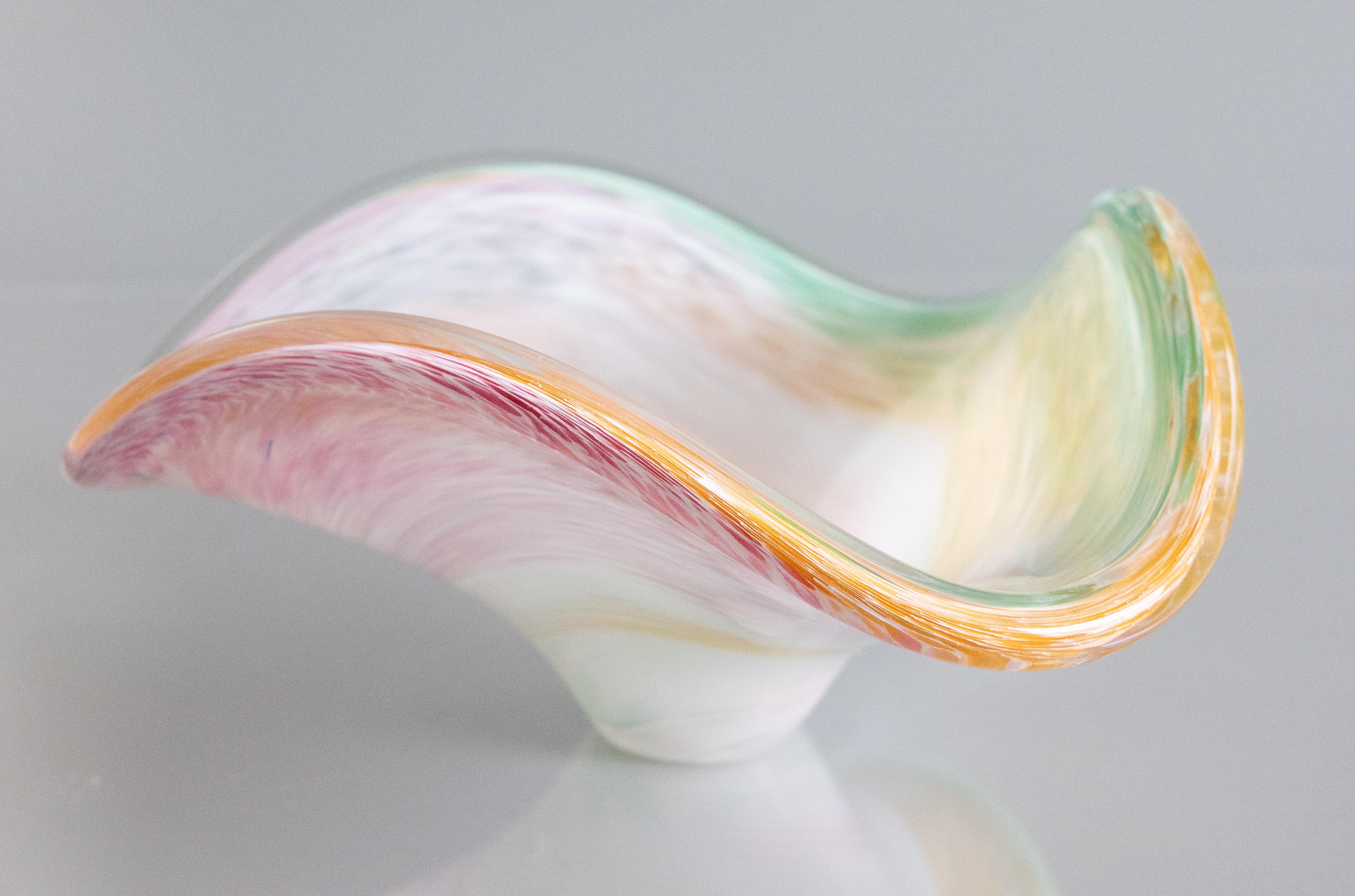 Un'elegante ciotola vintage in vetro artistico di Murano. Questa deliziosa ciotola è soffiata a mano con un elegante design ondulato e sfumature di verde, rosa e arancione. È un'esposizione meravigliosa e sarebbe un'aggiunta elegante a qualsiasi