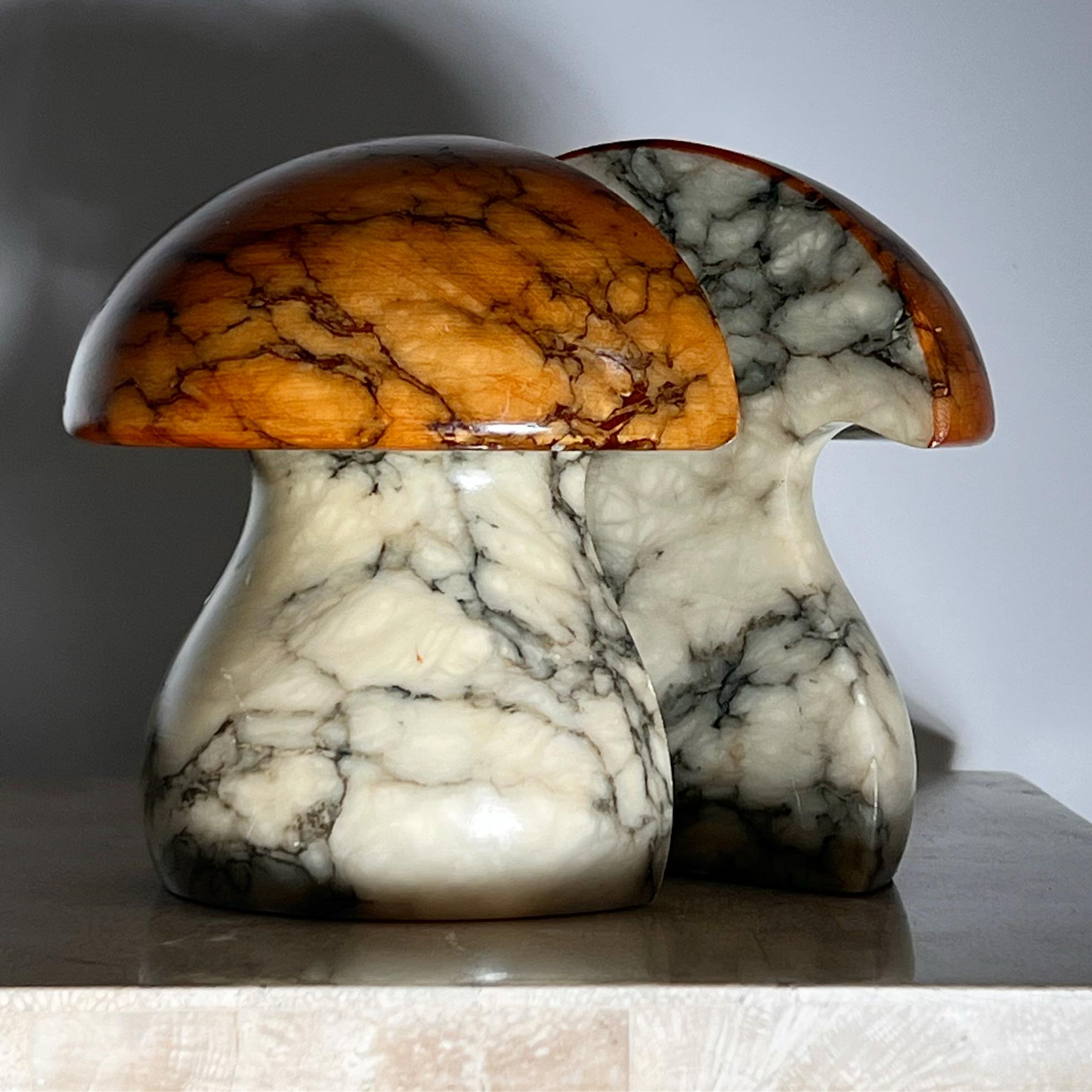 A pair of mushroom marble bookends by Noymer, hand carved in Italy circa early 1960s. Imported by Rico as the label portrays. Tones of coral and eggshell with ash and charcoal veining. Good condition with minor signs of wear.