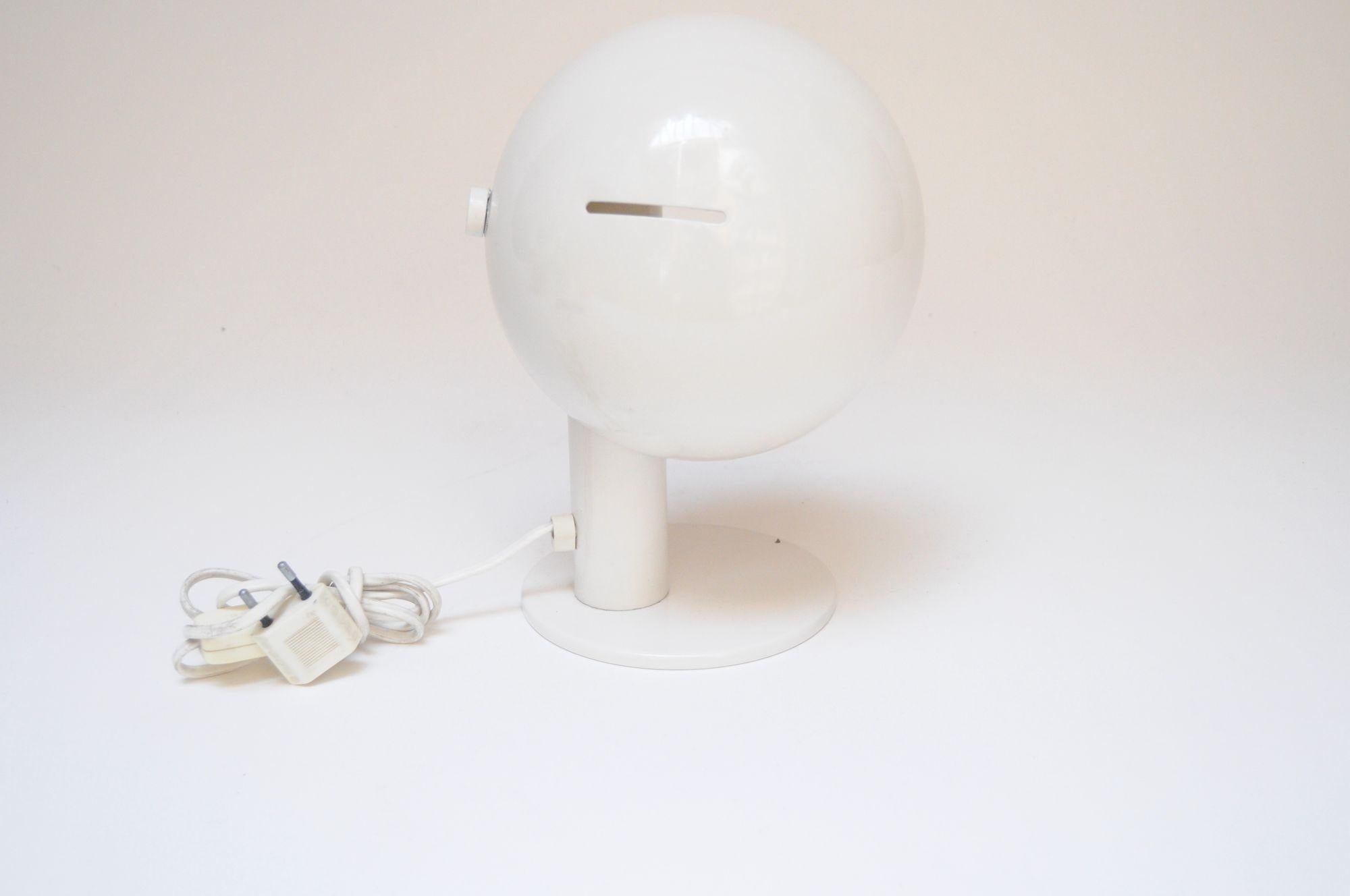 Petite lampe de table vintage en métal en forme de champignon qui a conservé son émail blanc d'origine avec une tige tubulaire et une base ronde (vers les années 1960, Italie).
L'abat-jour en forme de dôme pivote et peut s'ajuster sur son axe de 180