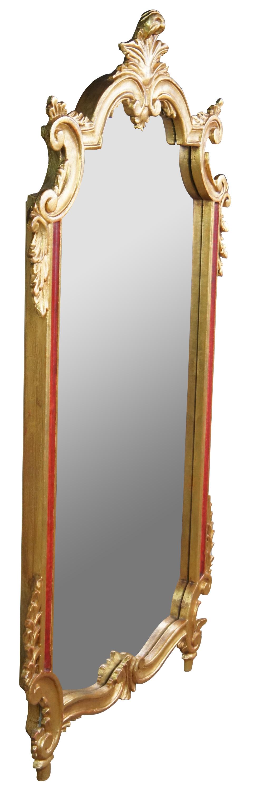 Vintage Italian Neoclassical wall vanity mirror featuring gilt wood with red accents and ornate acanthus motif. Made in Italy. Measures: 44