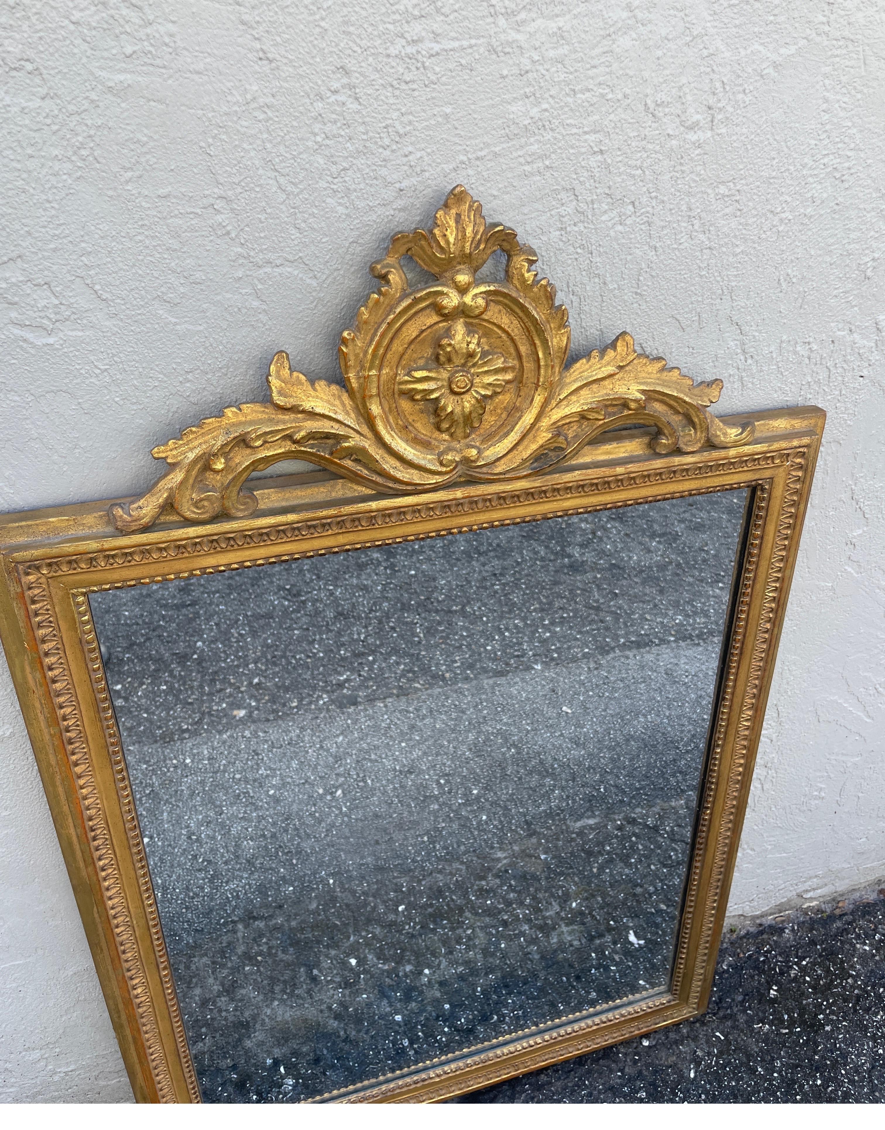 Vintage Neoclassical Giltwood mirror by Borghese. A rectangular shaped mirror adorned with a pediment at top.