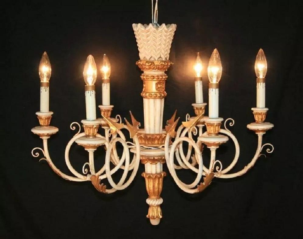 Bemerkenswerter italienischer Kronleuchter aus geschnitztem Holz, vergoldet und mit weißer Farbe verziert, im neoklassischen / Empire-Stil. Die Leuchte verfügt über sechs Lichter, geschwungene Eisenarme mit Pfeilakzenten, goldene Blätter und eine