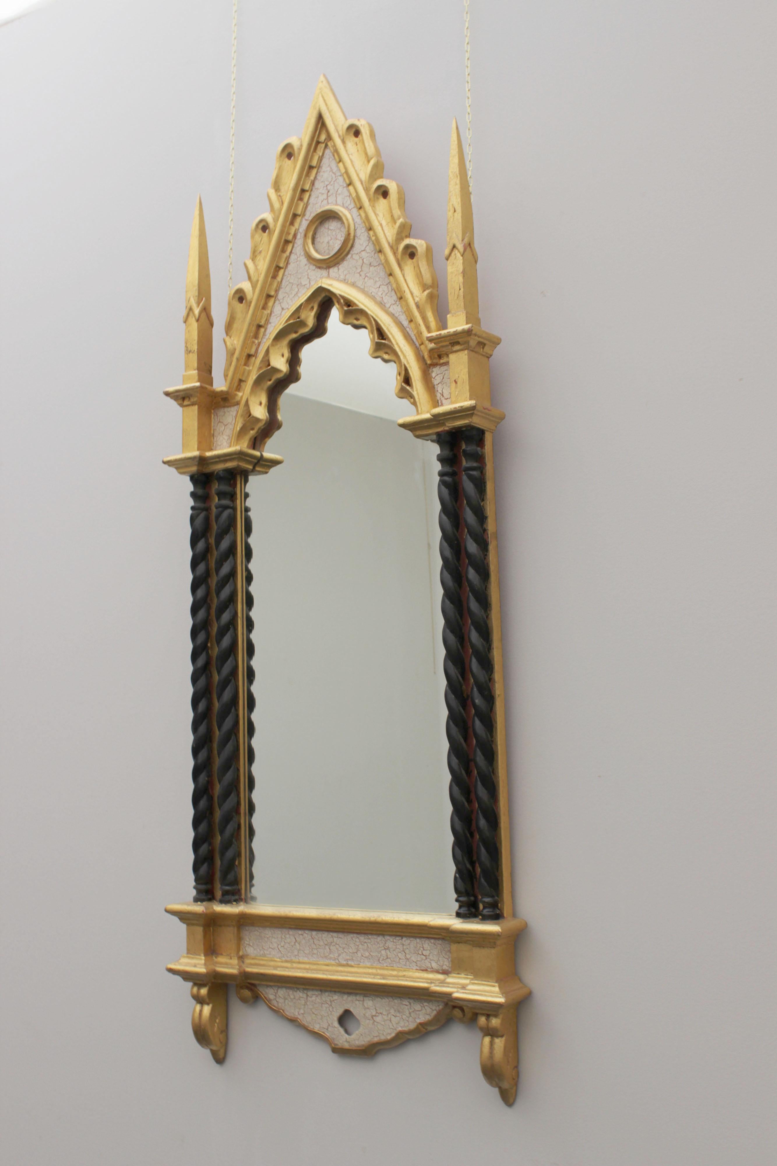Vintage Italian Neo Gothic mirror, 70's
Wonderful eclectic neo-gothic interpretation, carved and gilded wood on bolus, lacquered. The excellent ivory lacquering and the craquele effect that reveals the red background of the bolus. The twisted