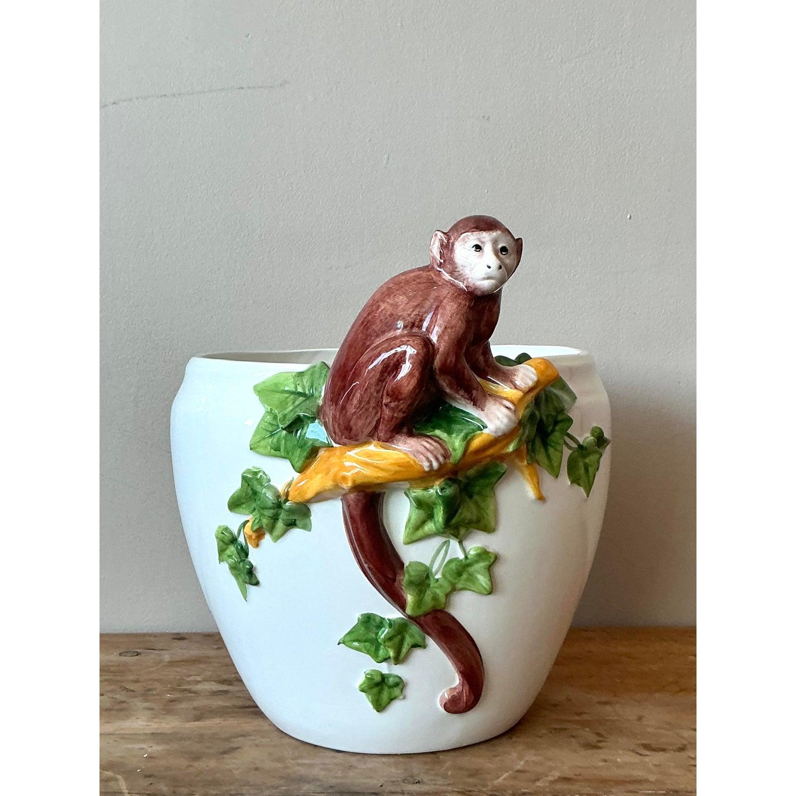 Lasciati incantare dall'eleganza giocosa di questo vaso vintage di Oggetti, un affascinante pezzo d'arte in ceramica smaltata della metà del XX secolo. Questa splendida fioriera presenta una scimmia meravigliosamente scolpita e appollaiata tra