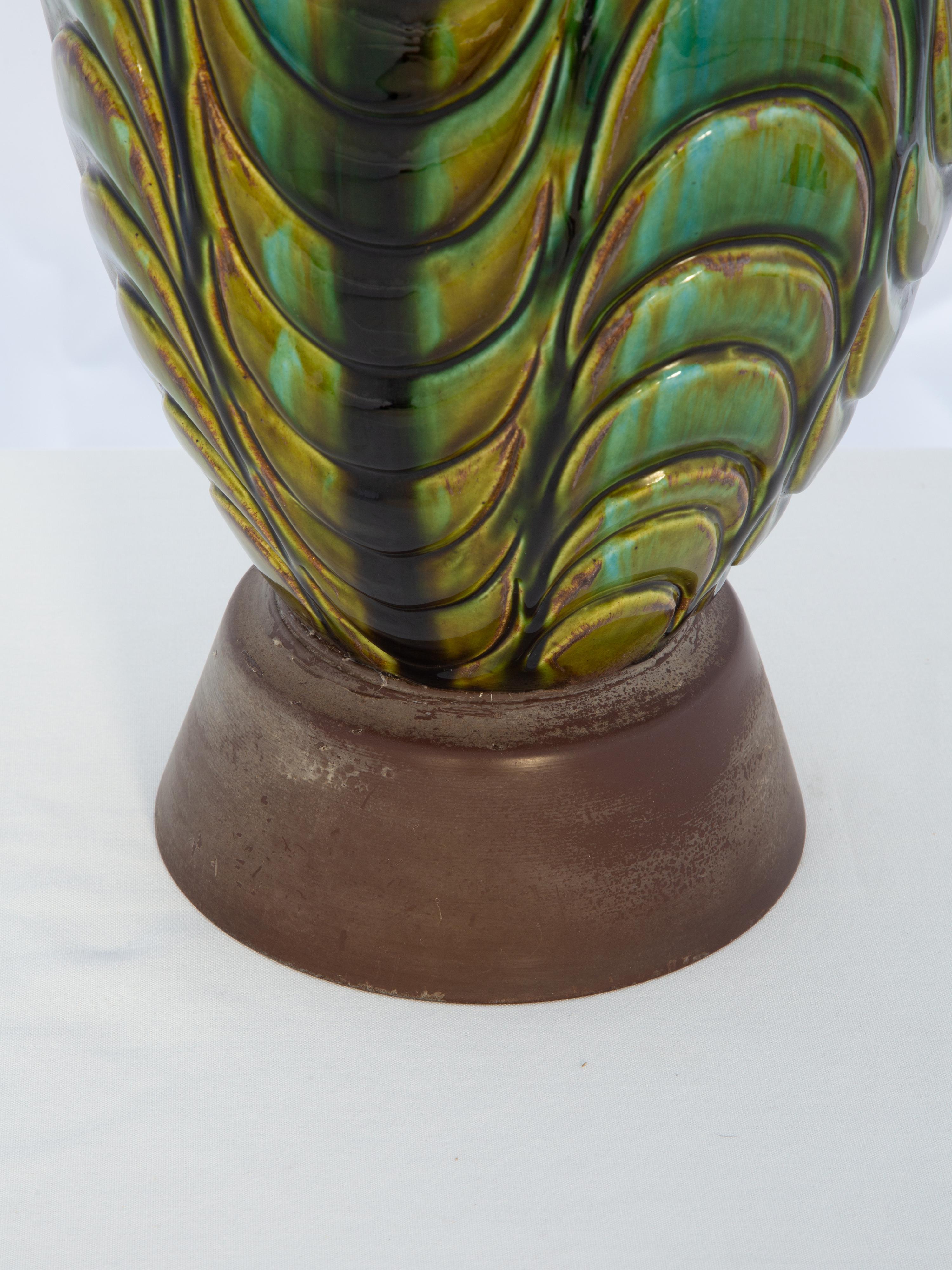 Lámpara italiana vintage en forma de jarrón, de cerámica pintada a mano, con esmalte de mayólica turquesa, dorado y oliváceo en su cuerpo festoneado invertido, elevada sobre una base redonda de madera. 

ID de stock: D4181