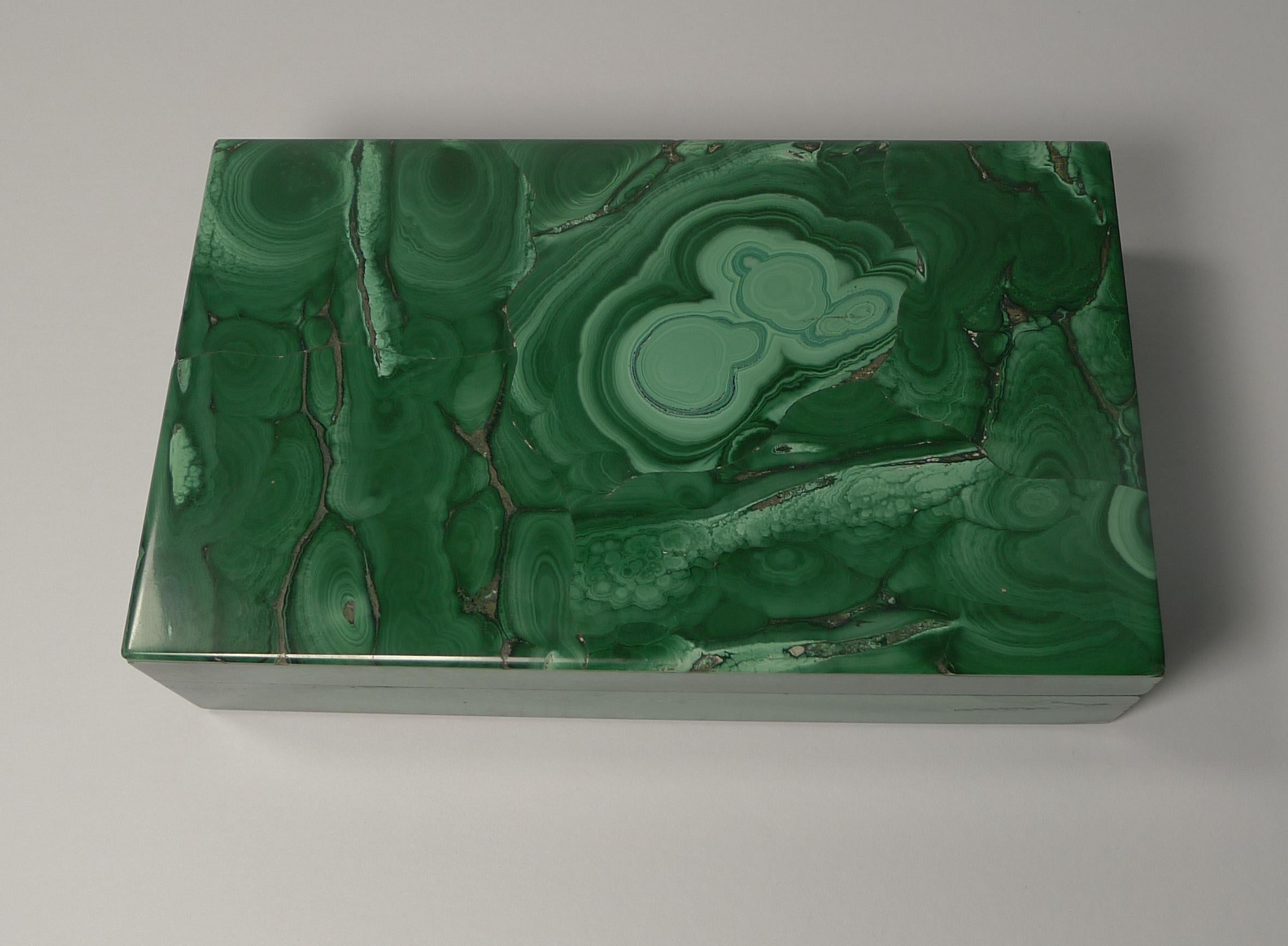A wonderful example of a Mid-Century Modern malachite box in a lovely simple Art Deco design.

The malachite is striking and in magnificent undamaged condition. The hinged lid is made from solid 800 silver and both the top and bottom is trimmed in