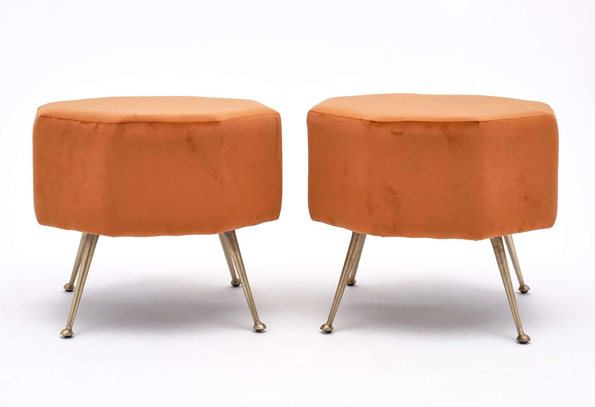 Pair of stools from Italy with flaring gilt brass legs and newly upholstered in a bright orange micro fiber.