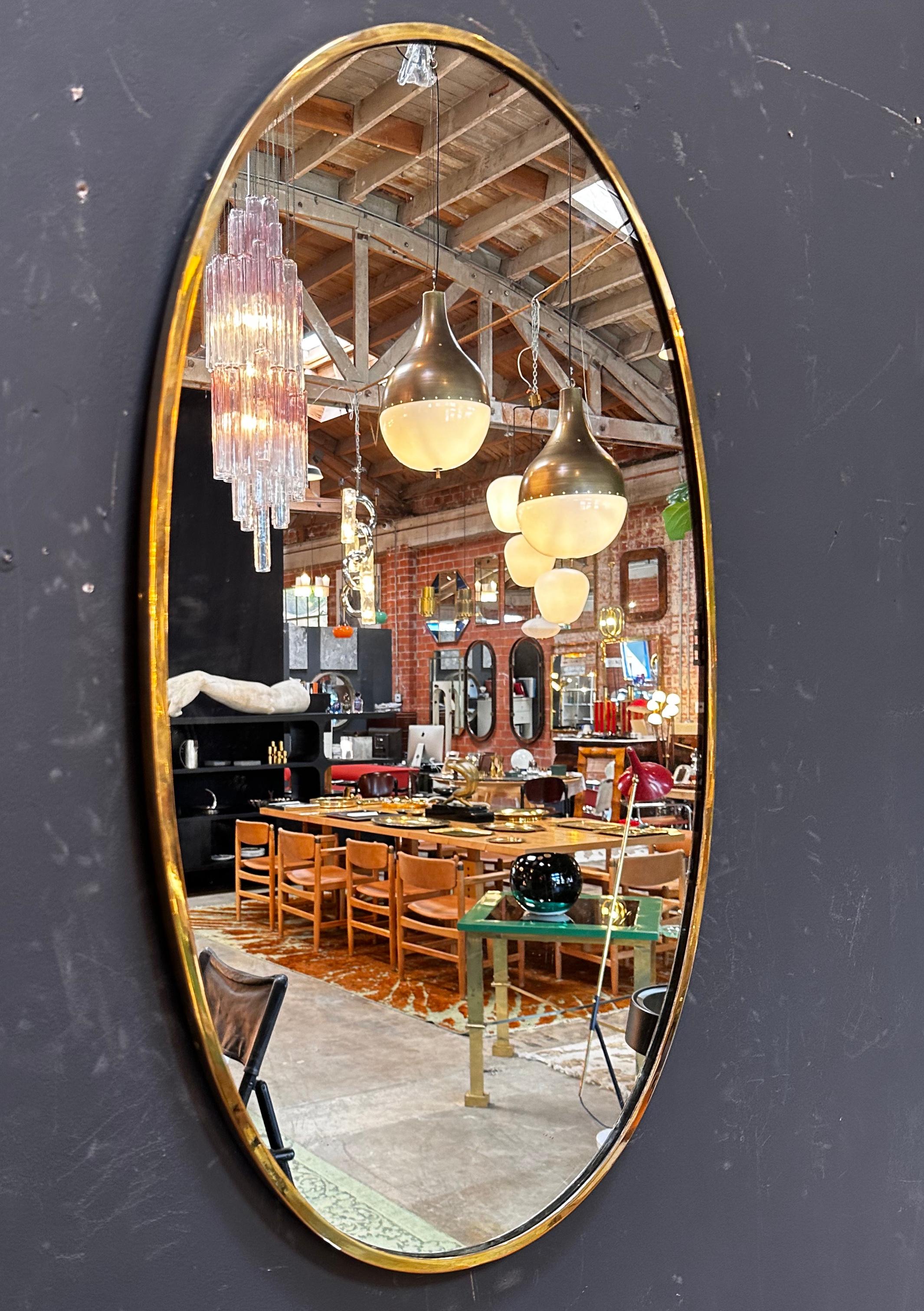 Der Vintage Italian 1980 Oval Brass Wall Mirror ist ein klassisches und elegantes Stück mit einer zeitlosen ovalen Form und einem schönen Messingrahmen.


