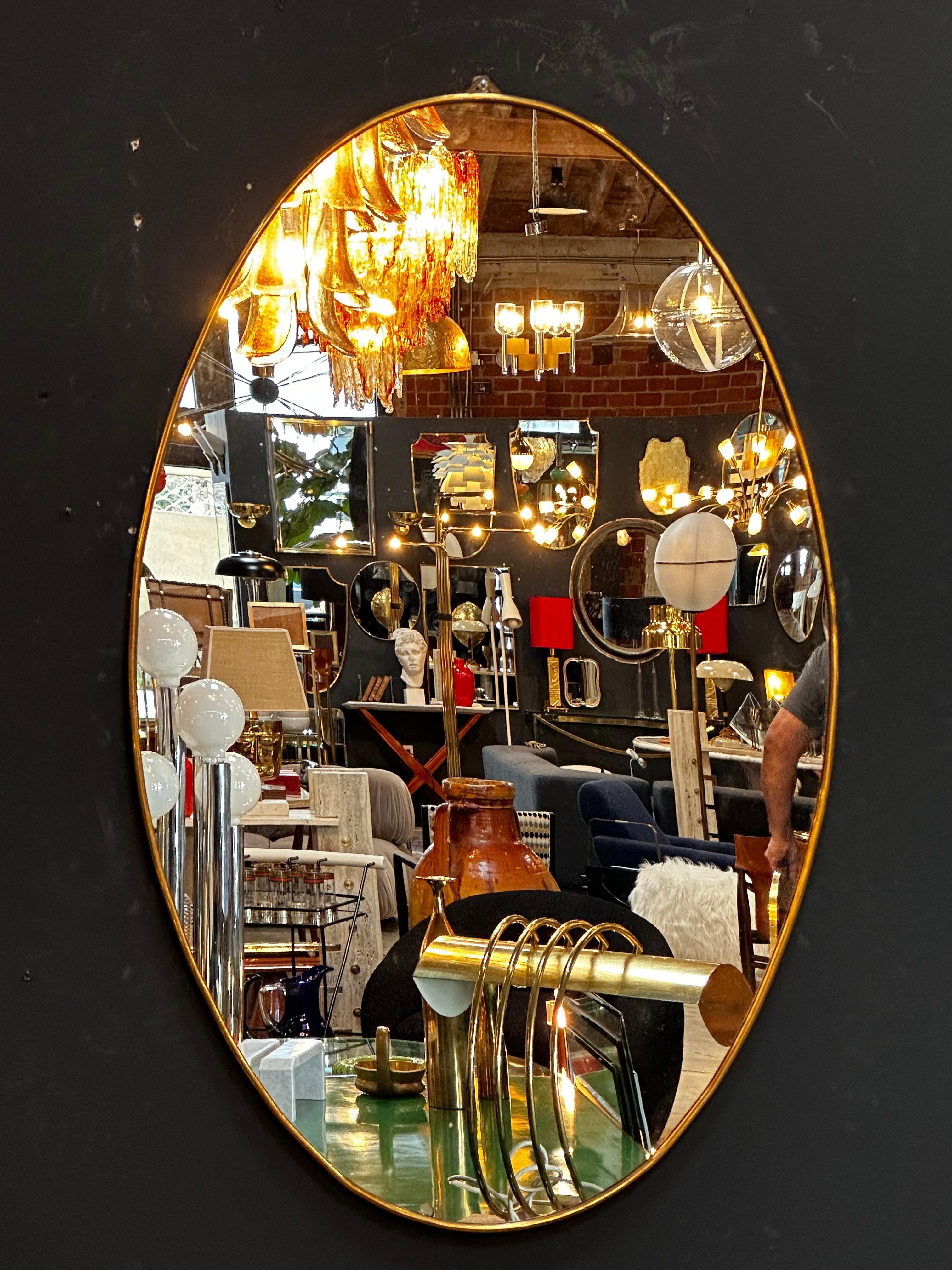 The Vintage Italian 1980 Oval Brass Wall Mirror is a classic and elegant piece with a timeless oval shape and a beautiful brass frame.

