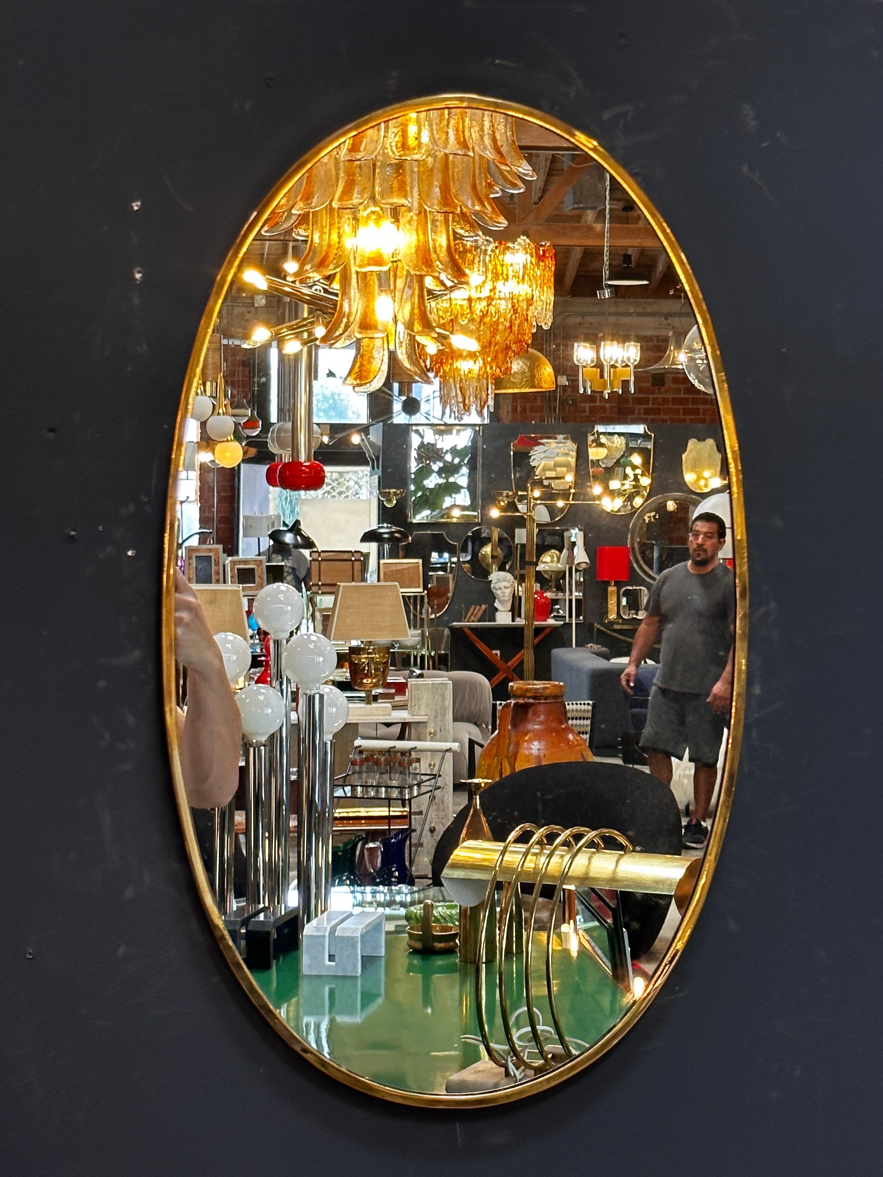 The Vintage Italian 1980 Oval Brass Wall Mirror is a classic and elegant piece with a timeless oval shape and a beautiful brass frame.


