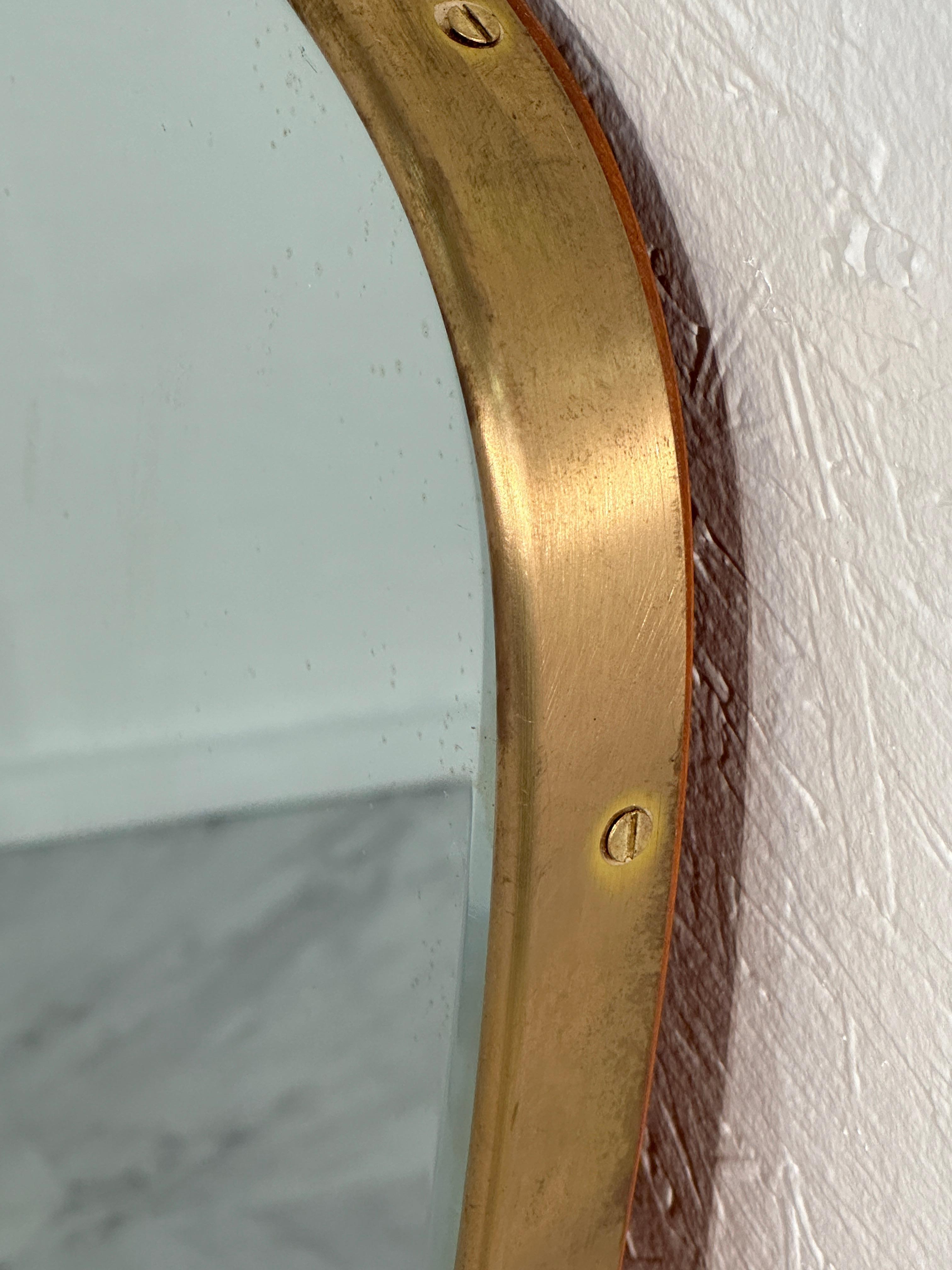 The Vintage Italian Oversize Brass Wall Mirror from the 1970s is a striking piece characterized by its unique wave shape and original patina. Crafted with attention to detail, its oversized design commands attention, while the brass material exudes