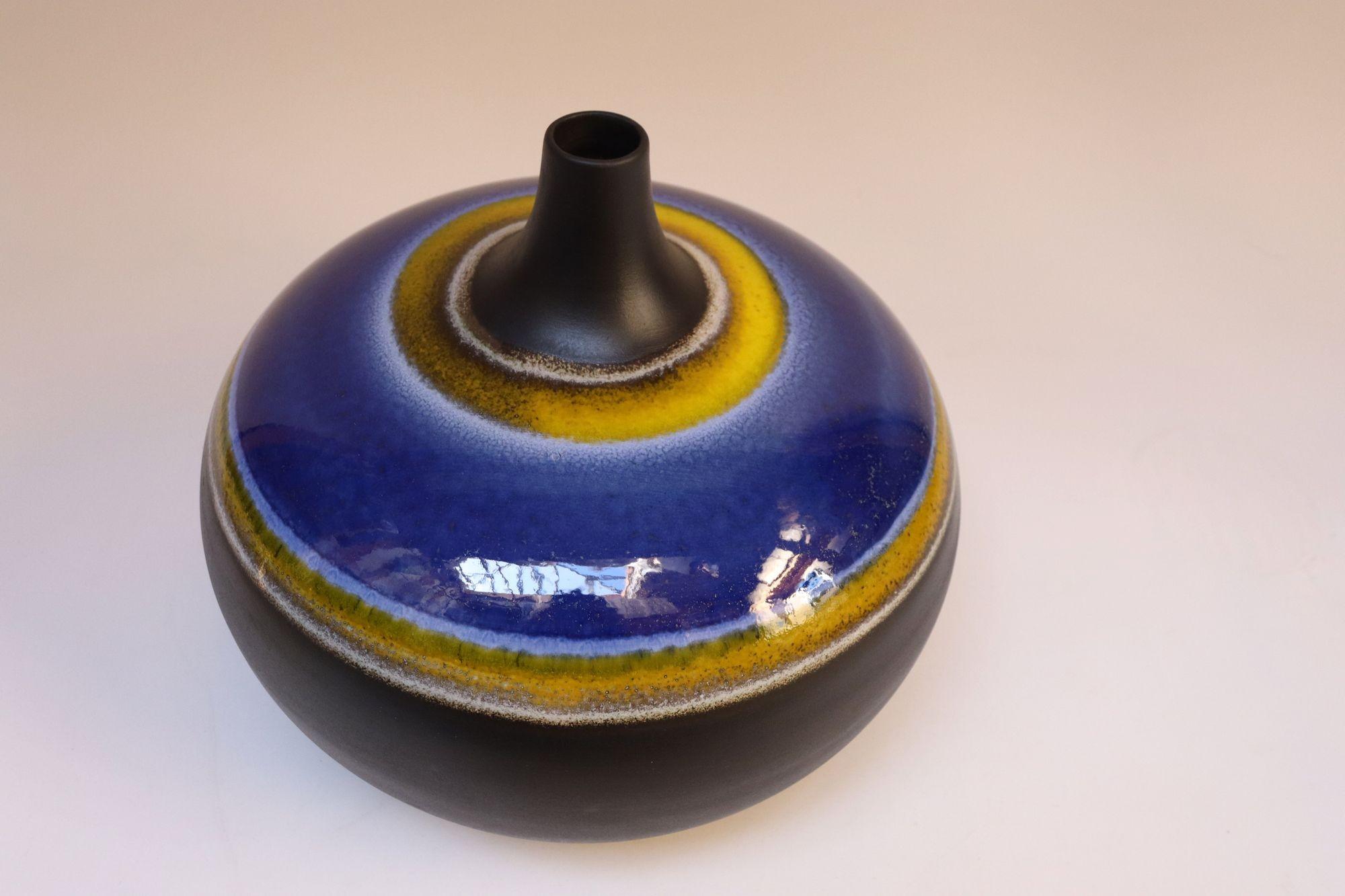Large ceramic vase in deep gray/ slate matte with glazed blue, white and yellow banding (ca. 1970s, Italy).
Attractive pops of bold colors against the slate backdrop and impressive size measuring H: 13.25
