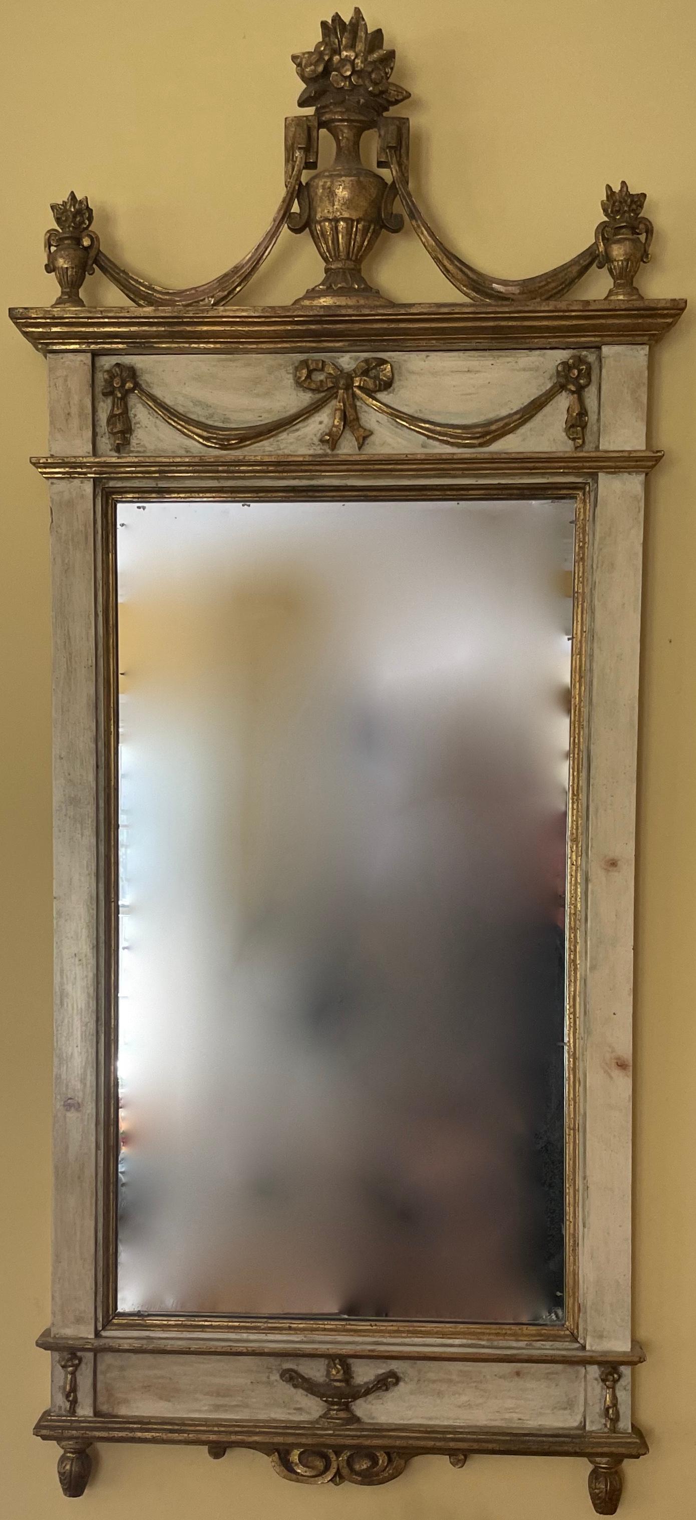 Vintage Italian painted and gilt carved mirror. Butter yellow painted and gilt carved mirror in the neoclassical style with swags, finials and central urn finial issuing flowers. Mirror plate is original with evidence of age. Italy,