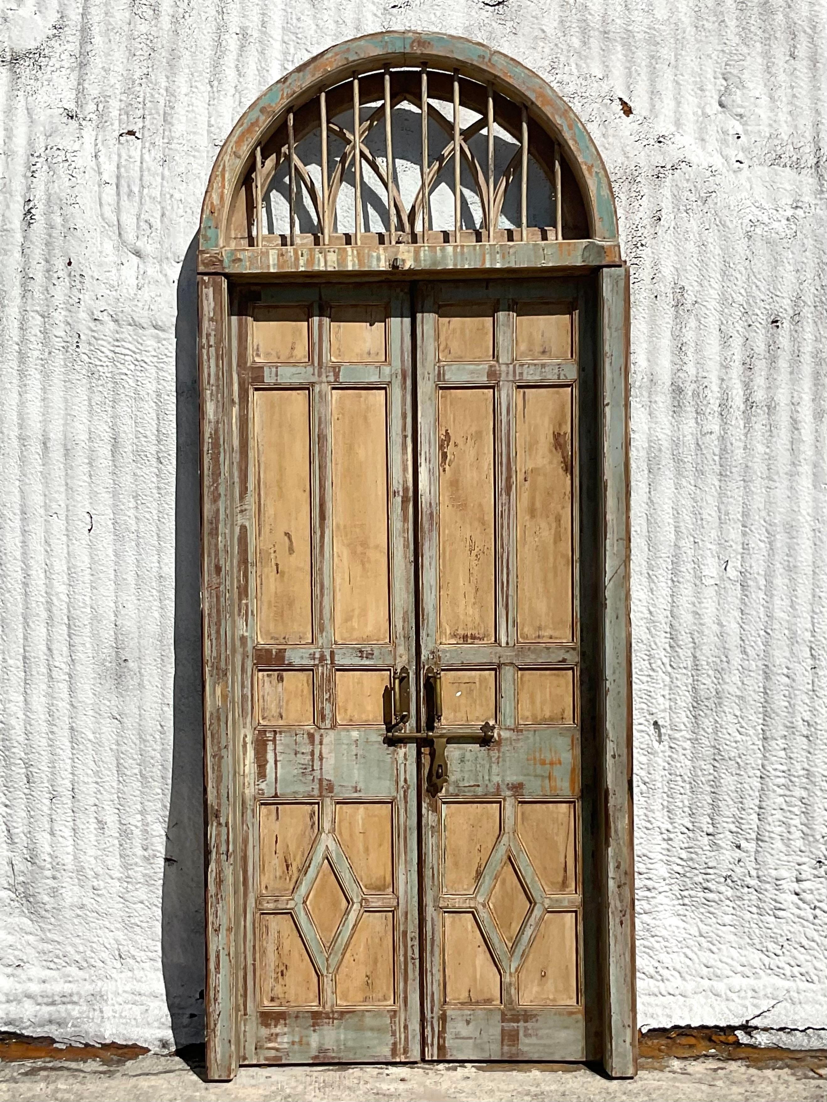An extraordinary pair of vintage Italian doors. Beautiful tall doors with coordinating working transom window above. The most incredible patina from time. Design a whole house around them! Acquired from a Palm Beach estate.