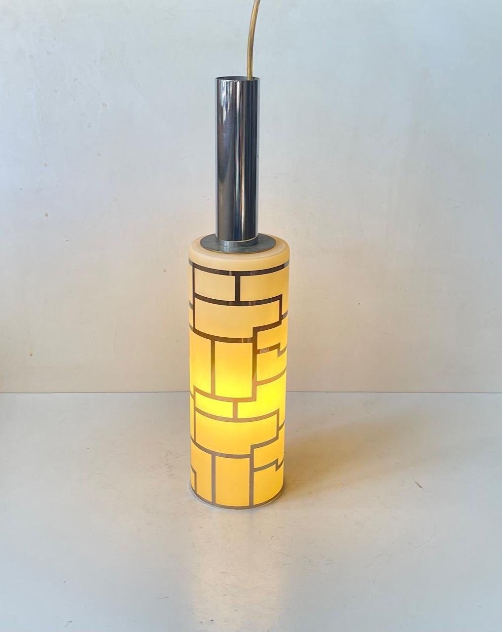 A mallet shaped hanging light featuring a cylindrical shade with cubist impressions/decor in chrome plating. Its top is made from chrome plated steel. Manufactured in Italy during the 1980s. Measurements: H: 43 cm, Diameter: 10 cm.