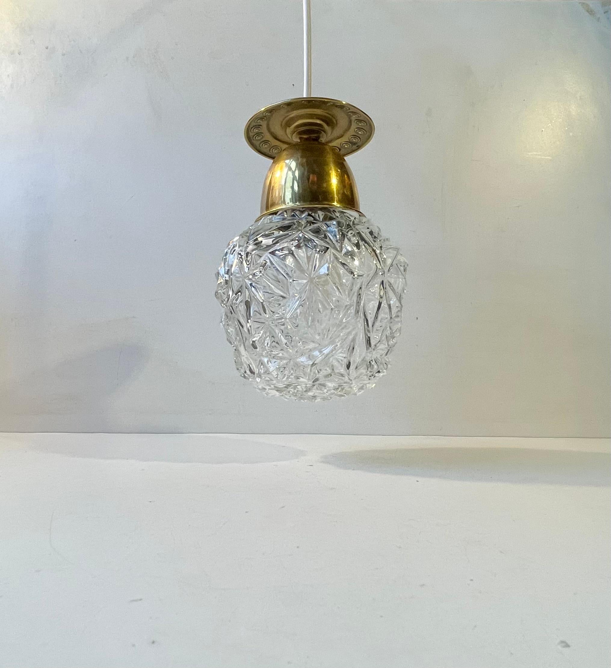 Small stylish hanging light featuring an ornamented brass top and a pressed glass shade. It was manufactured in Italy during the 1960s. Measurements: H: 21 cm, Diameter: 13 cm. Working and tested vintage order. Comes installed with 3 meters new