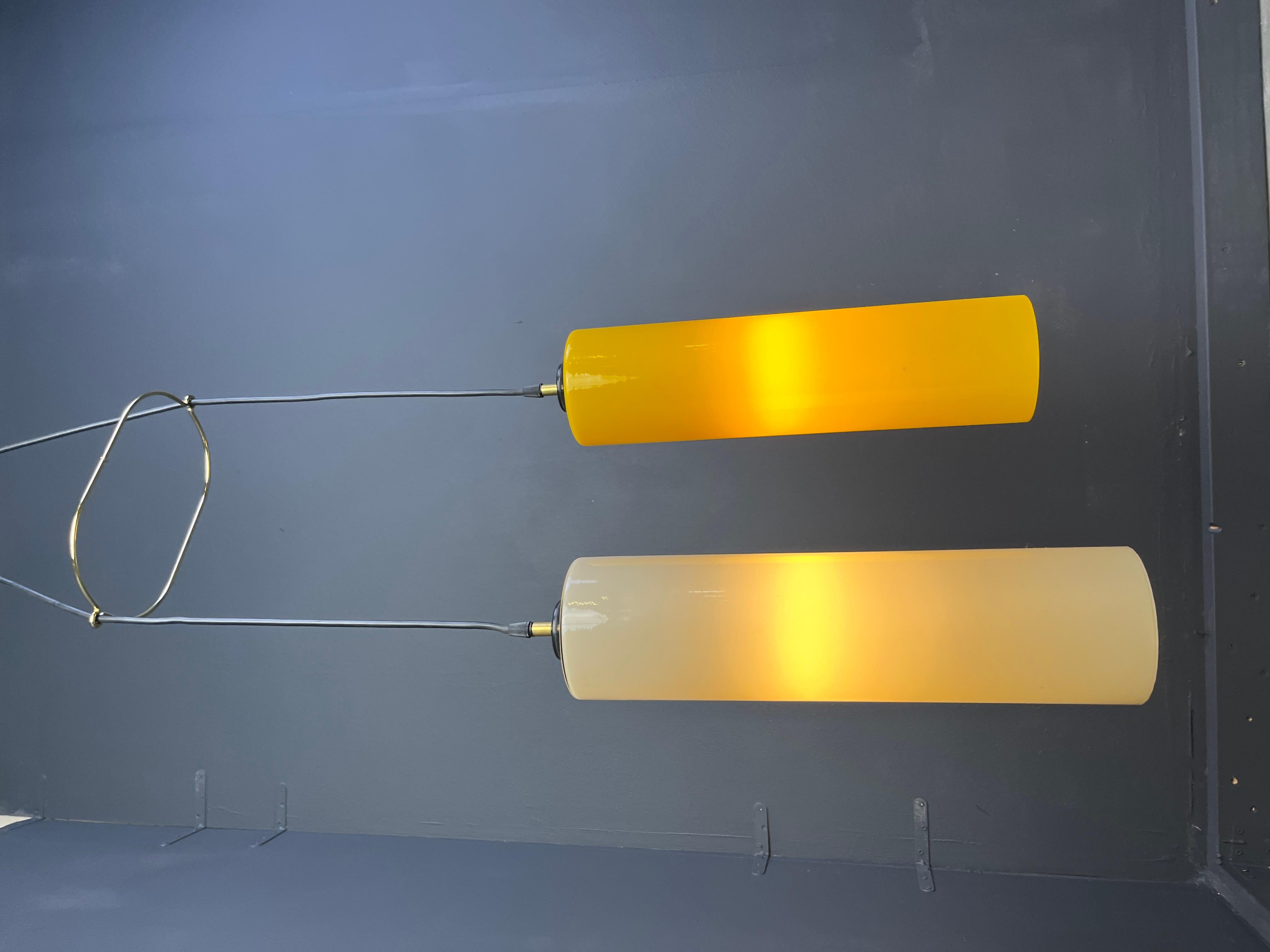 Large vintage yellow and beige glass pendant lights by Vistosi.

This chandelier or pendant lights are made out of italian glass attached to an adjustable black cord with brass hardware.

Timeless and warm lights.

Tested and ready to use with