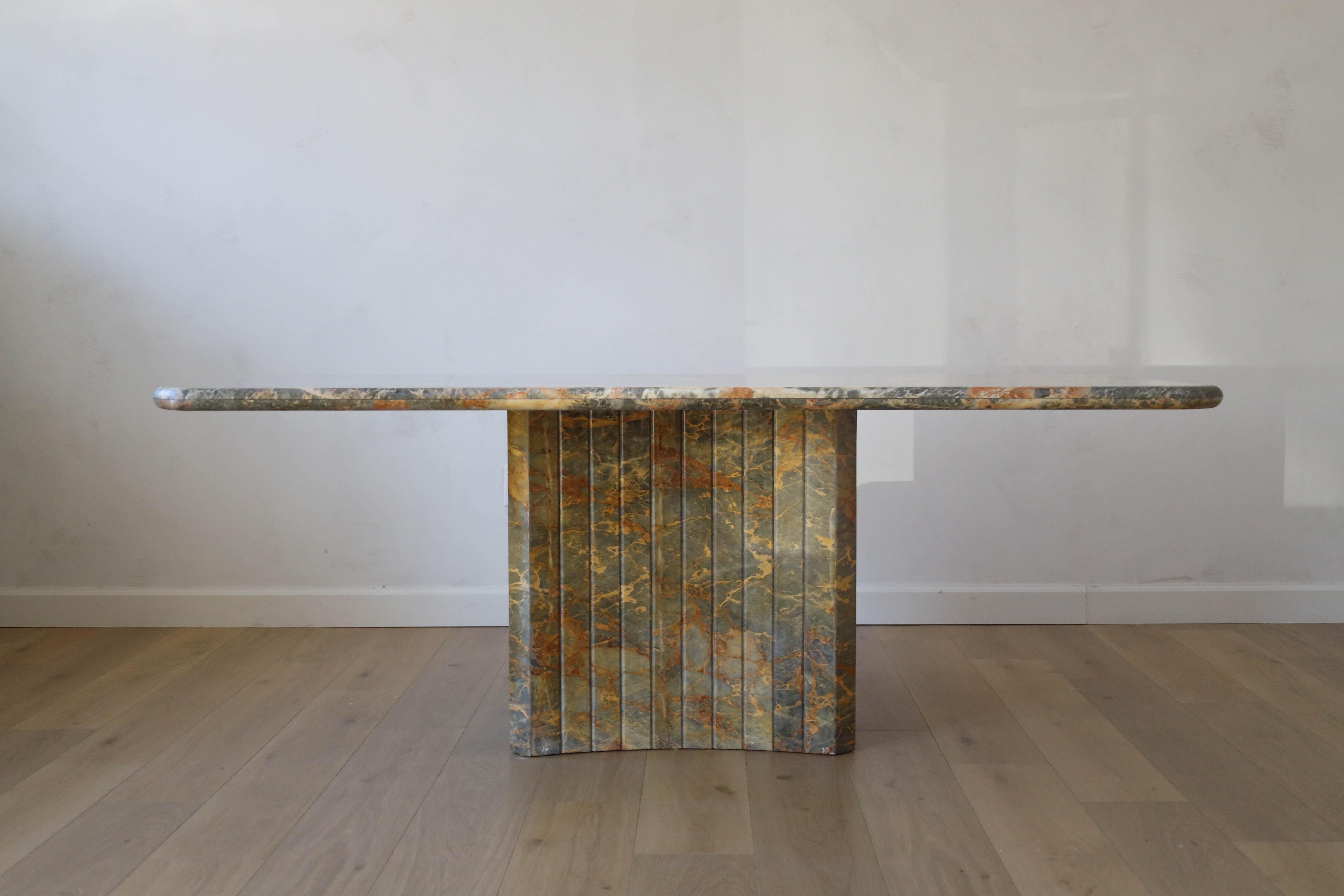 This rare 1980s Italian Fior di Pesco marble dining table is a timeless statement piece for your home. The marble offers a beautiful blend of grey and pink coloring with white and orange undertones blended into the movement of the stone. Your eye