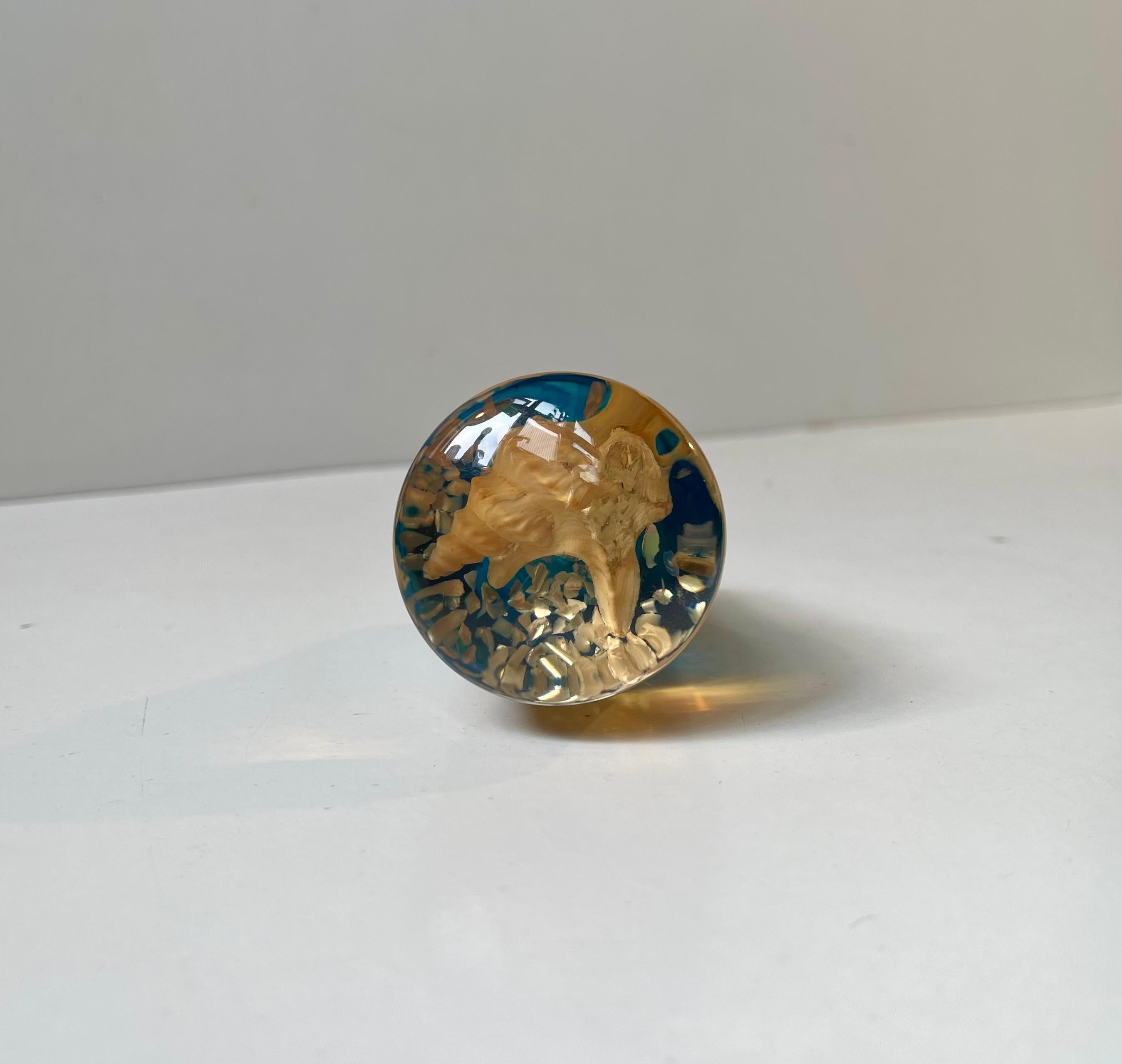 Einzigartiger Schaltknauf aus Plexiglas mit eingekapselten Meeresmuscheln. Dreifarbiges Plexiglas, das die Sonne, den Sand/Erde und das Meer symbolisiert. Hergestellt in Italien in den 1960er oder 70er Jahren. 

Abmessungen: L: 7,5 cm, Durchmesser: