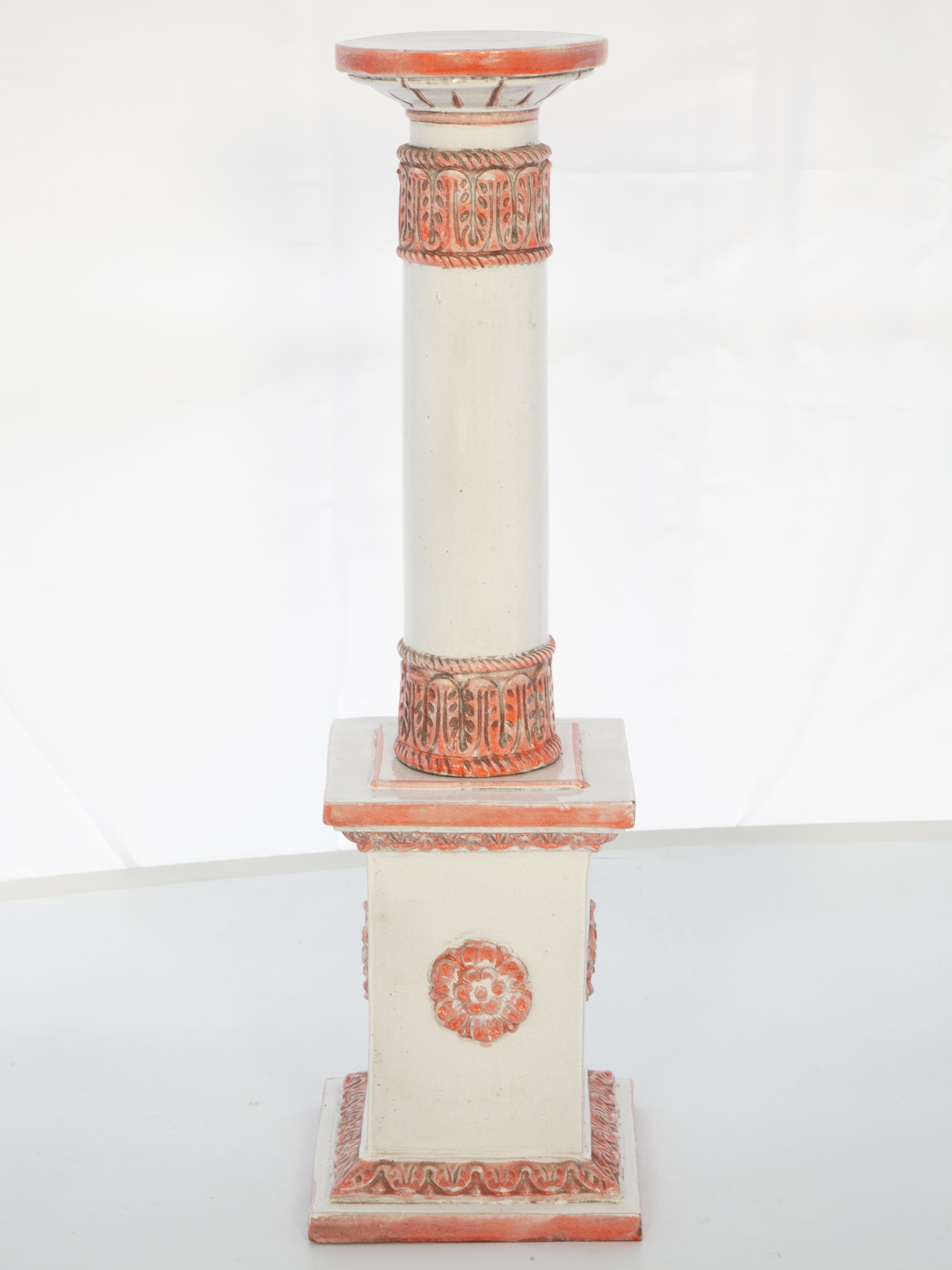 Pedestal stand, of glazed terracotta, having a round top with canted apron, raised on a central column decorated by a meandering capital and matching collar, its graduating plinth base centered with a large rosette.

Top (Diameter): 9 in

Please