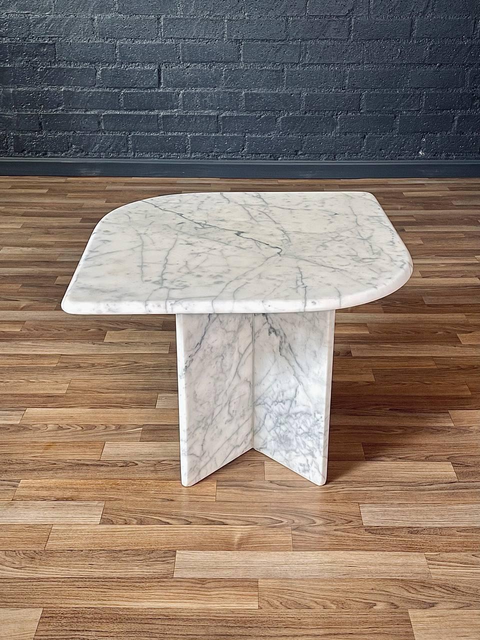 Condition: Original Vintage Condition 
Materials: Italian Carrara Marble

Crafted in Italy in the 1970s, this vintage side table is a striking example of Post Modern design, carved entirely from luxurious Italian Carrara marble. Its sculptural