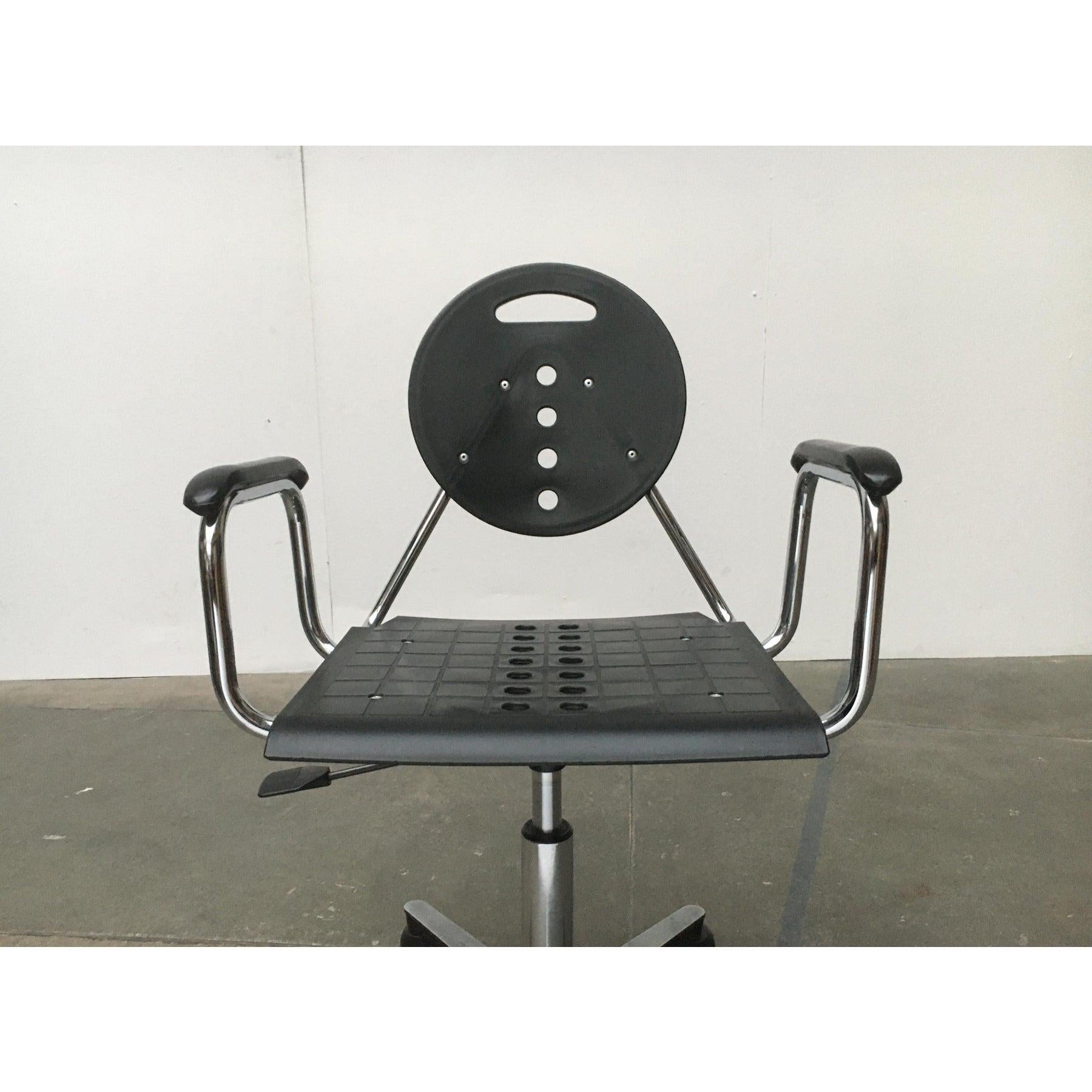 Un diseño fuertemente influido por un lenguaje postmoderno de la forma y la materialidad. Las superficies de plástico negro se aplican a un marco de acero tubular cromado. Forman el asiento y el respaldo de la silla y están provistos de llamativas