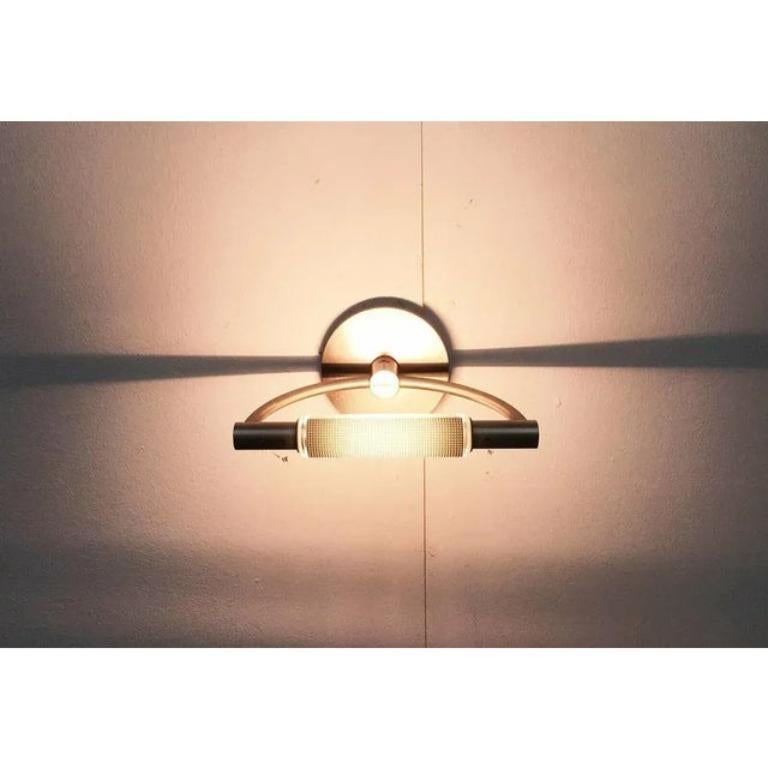 Elegant wall or ceiling light from Cini & Nils from the Gradi series.

The glass cylinder on the light head can be rotated manually. It has different pages and serves as glare protection and to adjust the lighting effect. The angle of the light head