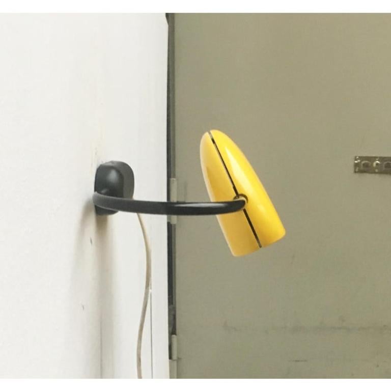 Postmodernism wall lamp by Luci Italia, designed by the Japanese designer Toshiyuki Kita from the 80s. Kita, the draft for the known Wink chair comes.

The lamp is completely decorated in yellow and black. A striking contrast between the arm and