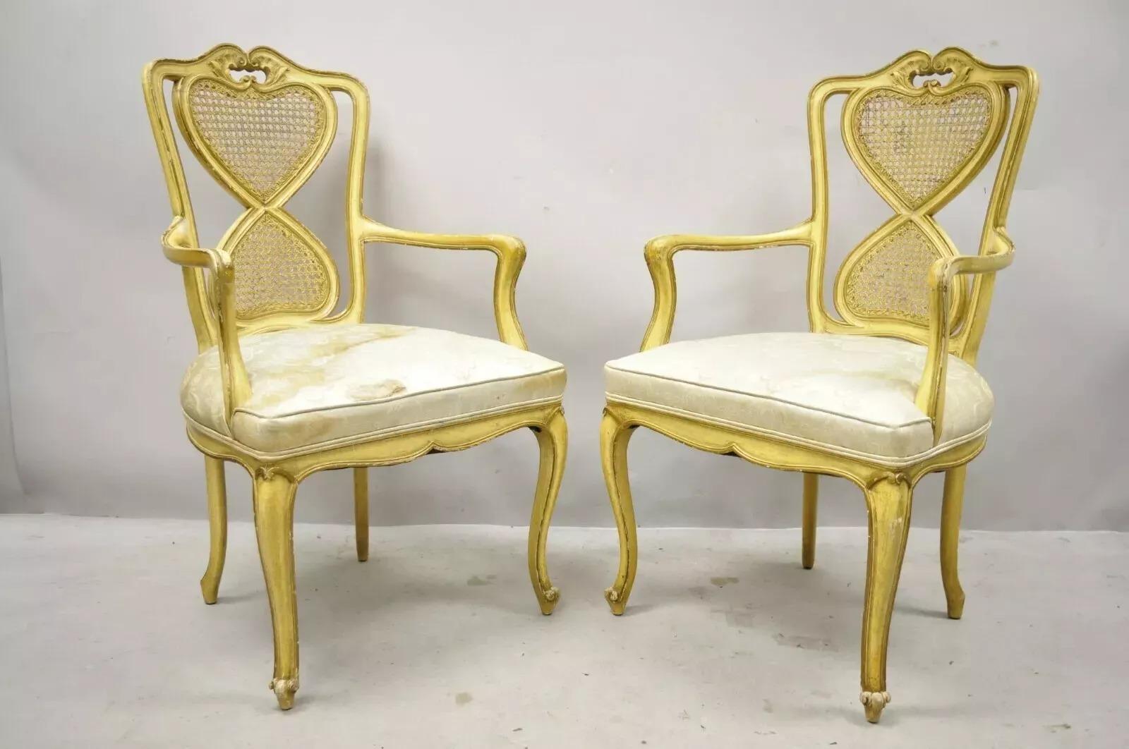 Vintage Italian Provincial French Louis XV Style Yellow Cane Dining Arm Chairs - a Pair. Item features cane backs, solid wood frame, distressed finish, cabriole legs, quality craftsmanship, great style and form. Circa Mid 20th Century. Measurements: