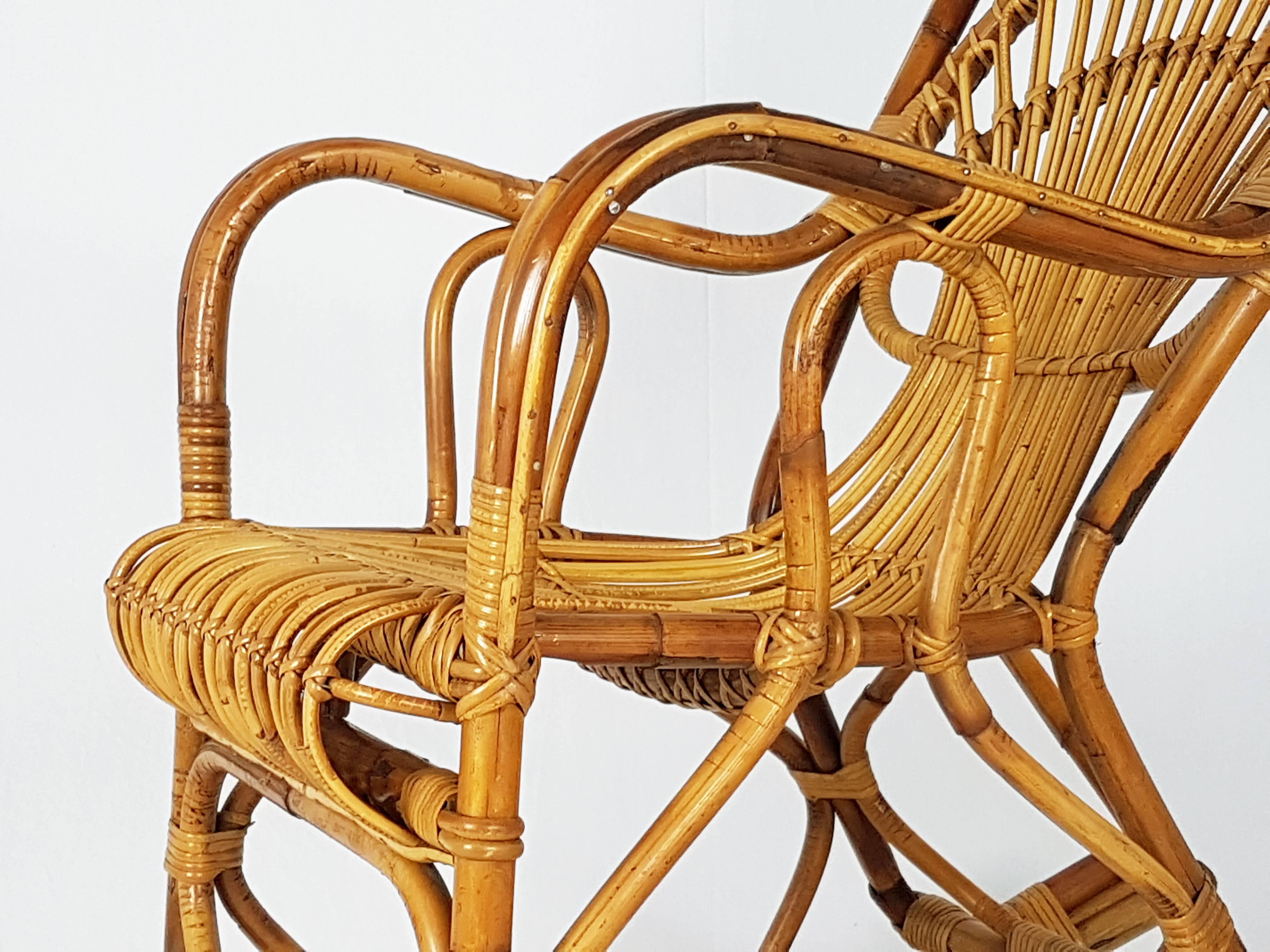 Cette magnifique chaise à bascule a été produite en Italie dans les années 1960. Il est fabriqué à la main en rotin et reste en très bon état vintage, quelques pertes de jonc près de la base comme le montre la photo. Légère usure conforme à l'âge et