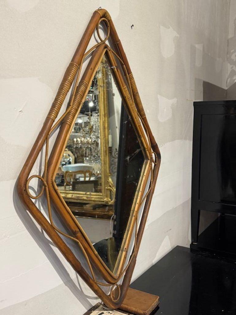 Lo specchio a forma di diamante in bambù e rattan italiano vintage è un pezzo unico ed elegante che aggiunge un tocco di fascino retrò a qualsiasi spazio. Caratterizzato da una cornice a forma di diamante in rattan e bambù, questo specchio richiama