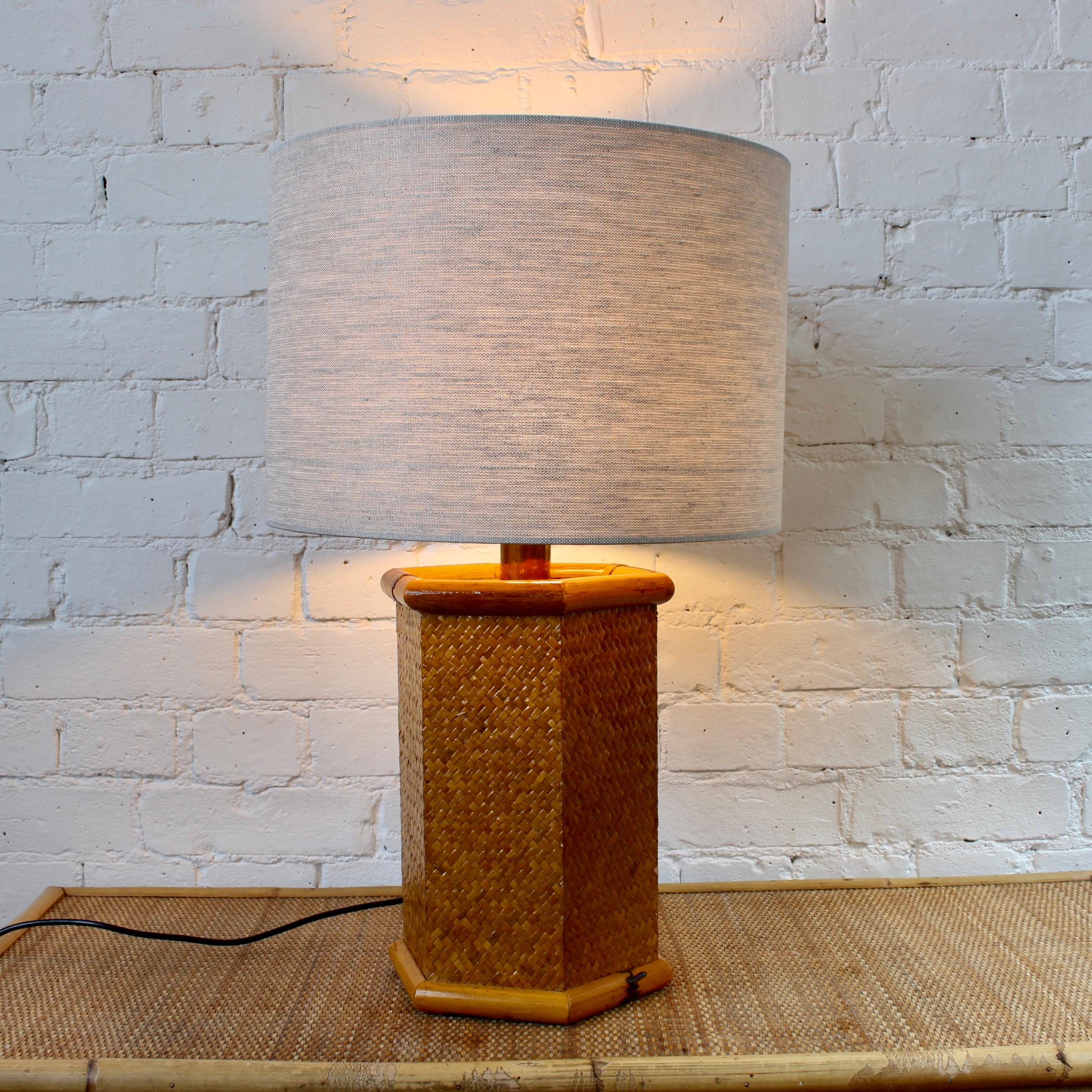 Lampe de table vintage italienne en rotin et bambou (circa 1970). Lampe de table de forme hexagonale avec du rotin tressé au milieu de deux cannes de bambou en haut et en bas, fournissant un support structurel à la pièce. Cette lampe nous transporte